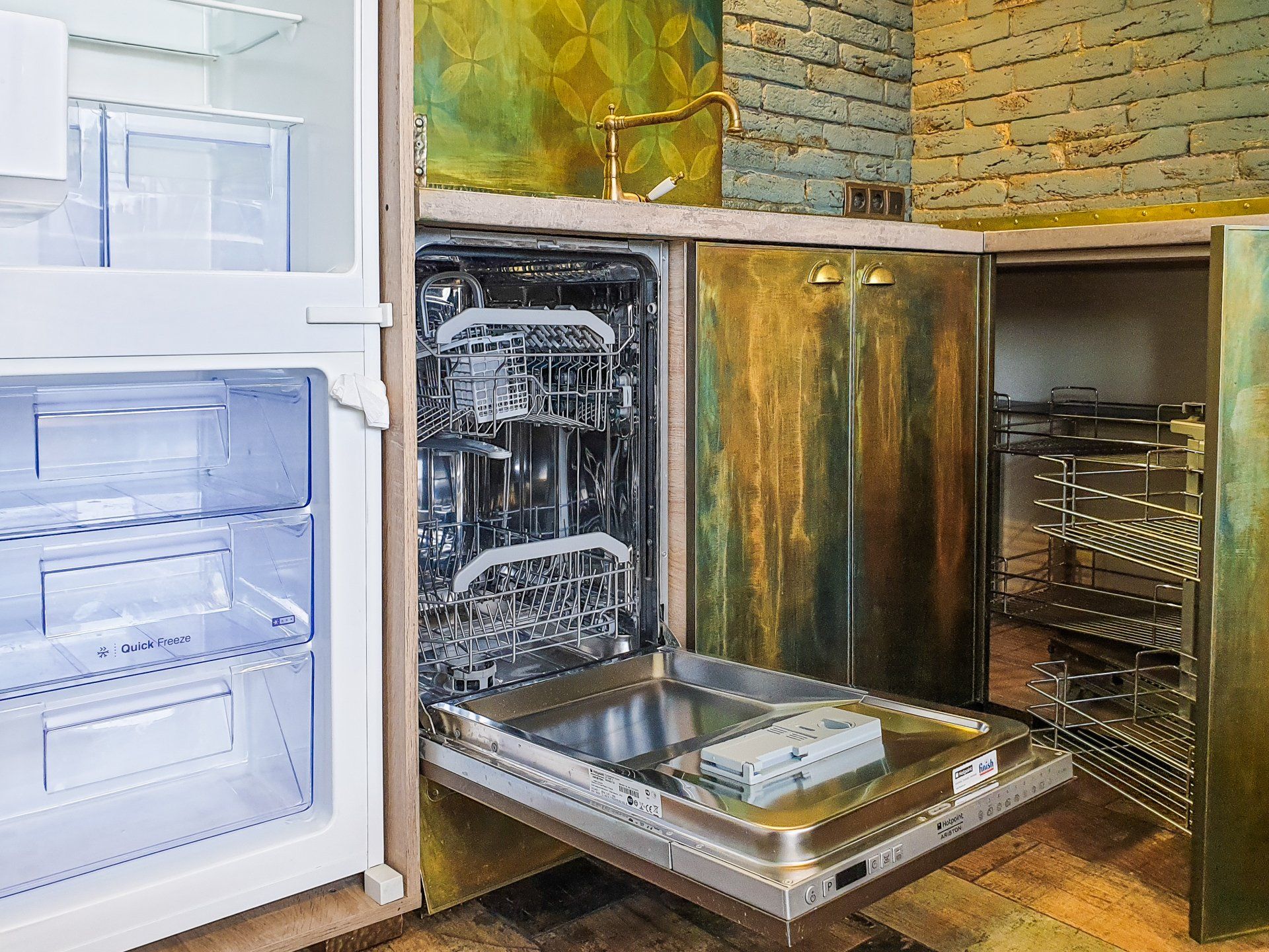 a dishwasher is open in a kitchen next to a refrigerator .