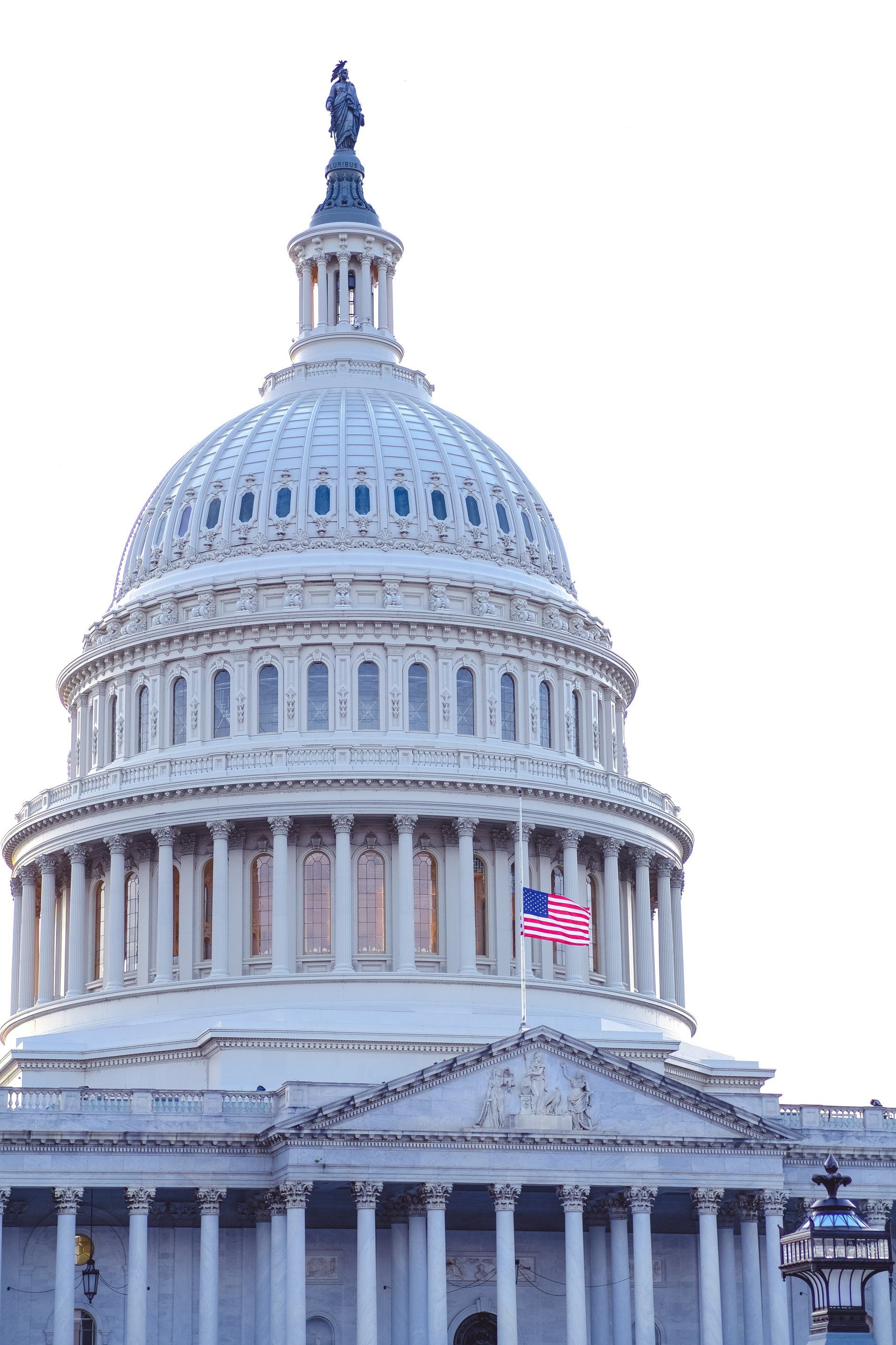 The dome of the capitol building in washington d.c. with an american flag flying in front of it.