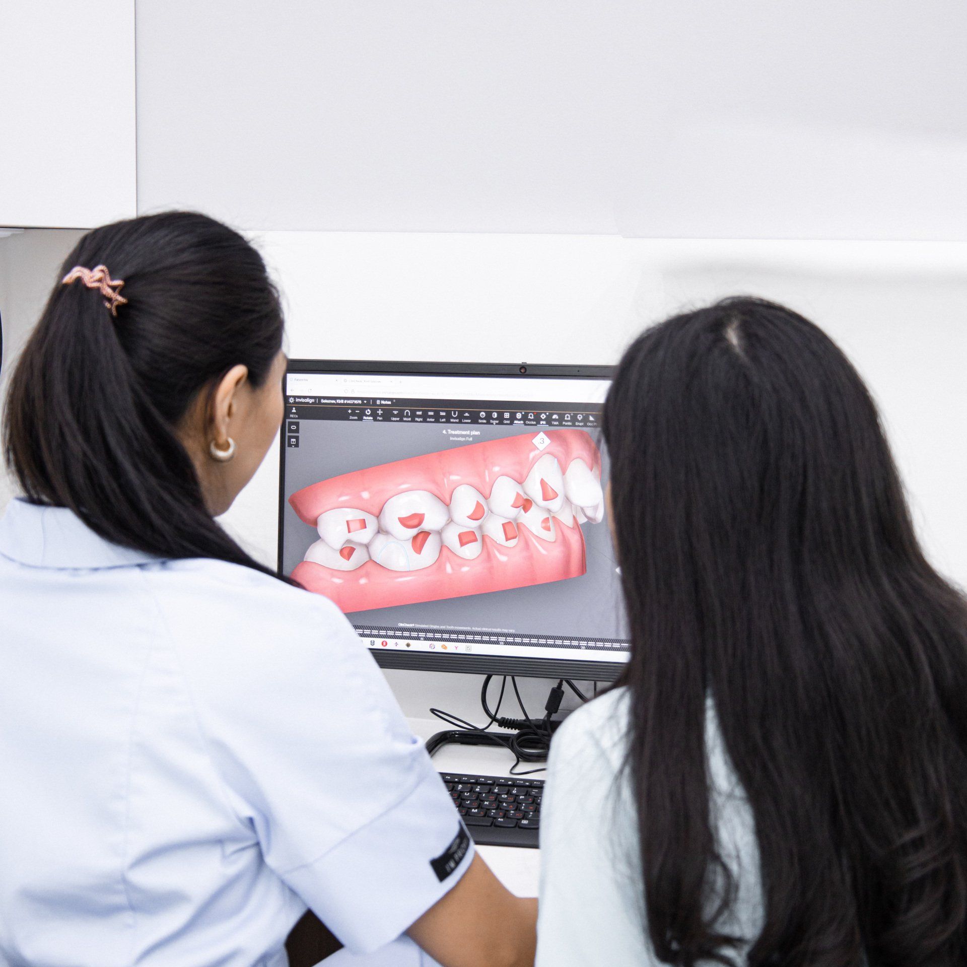 Dentista mostrando a um paciente uma imagem 3D de dentes em uma tela de computador em uma clínica.
