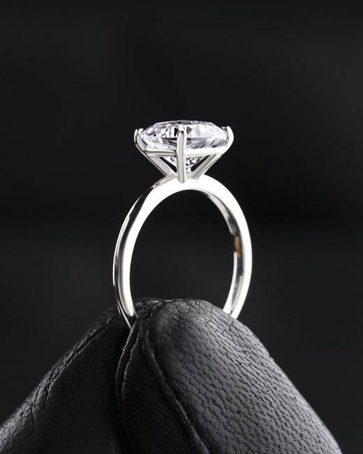 A person is holding a diamond ring in their hand.