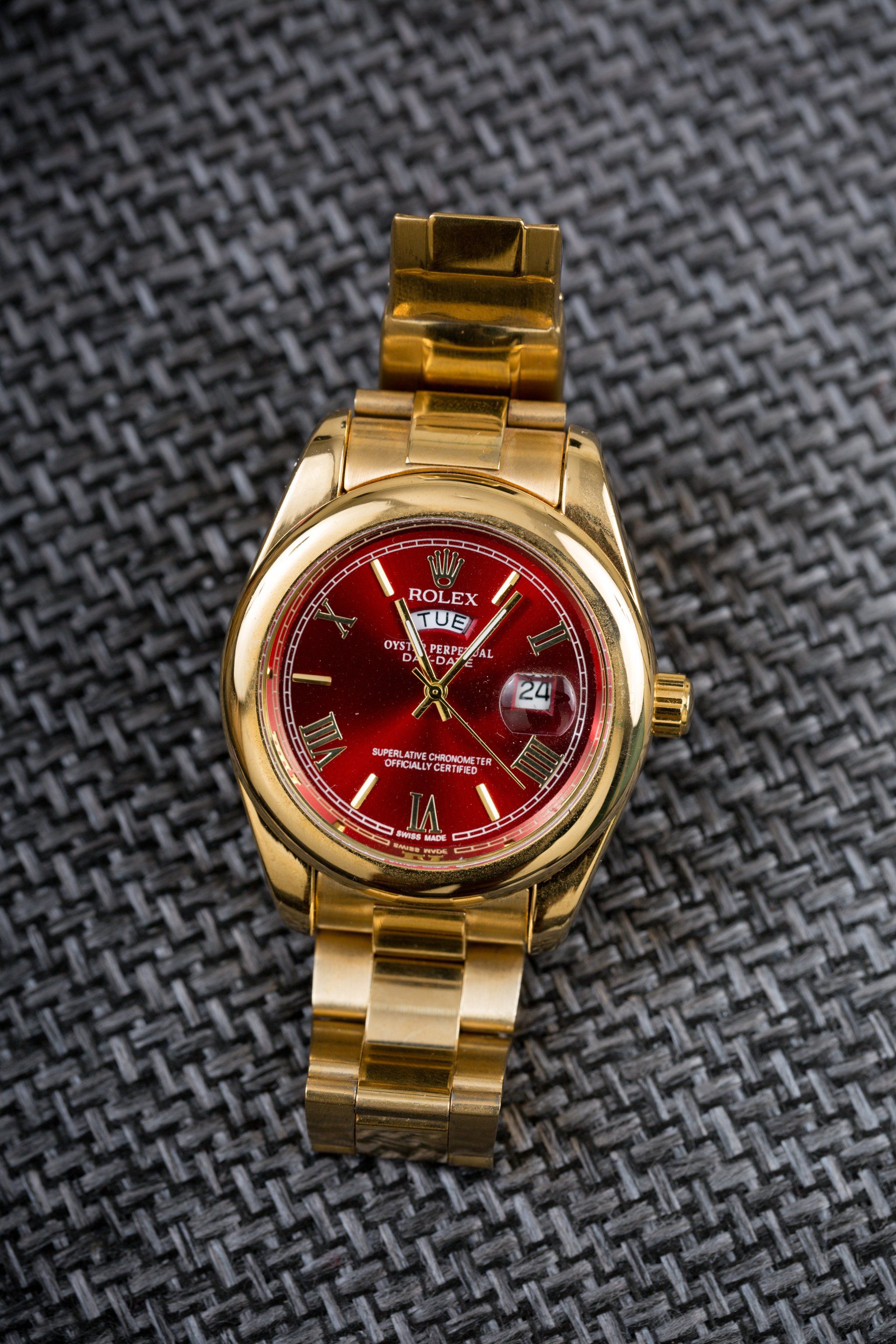 watch with gold case and band with red dial