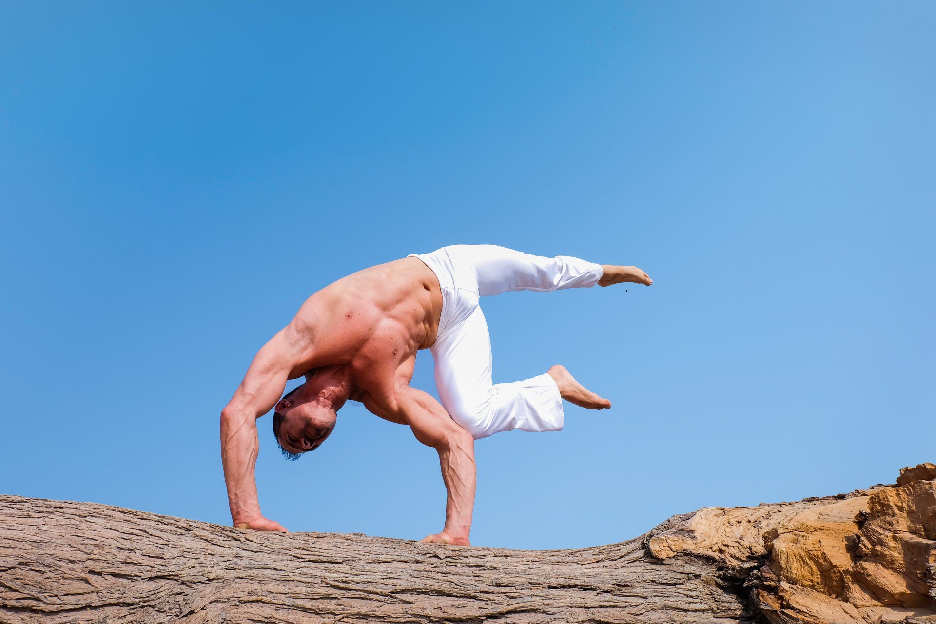 man doing aerobics in the middle of nowhere with white pants