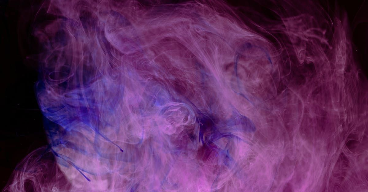 A close up of purple and blue ink in water on a black background.