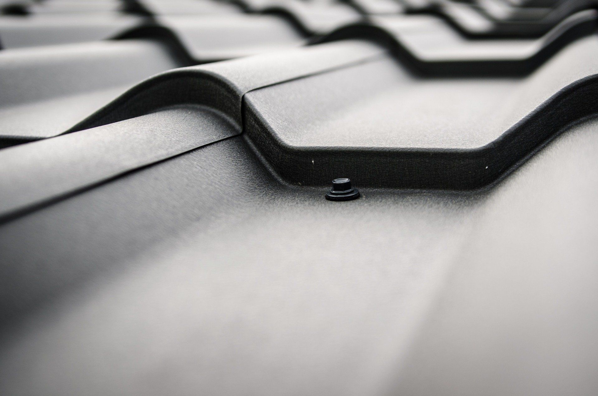 a close up of a black roof with a screw in it .