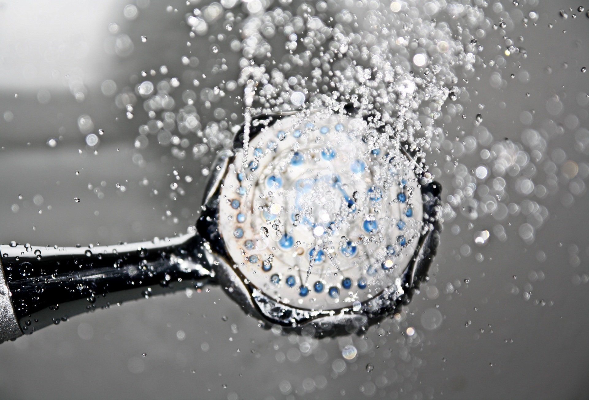 A picture of a shower head releasing water