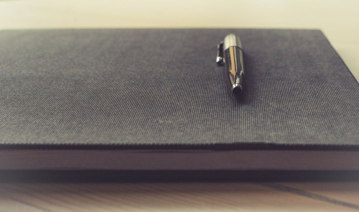 una penna professionale appoggiata sopra un quaderno