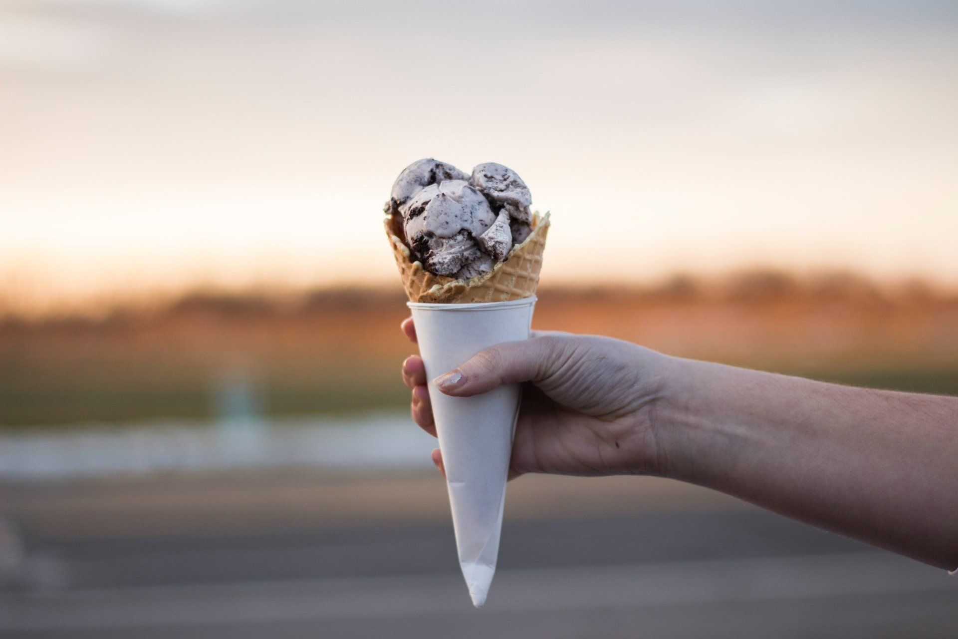 A person is holding an ice cream cone in their hand.