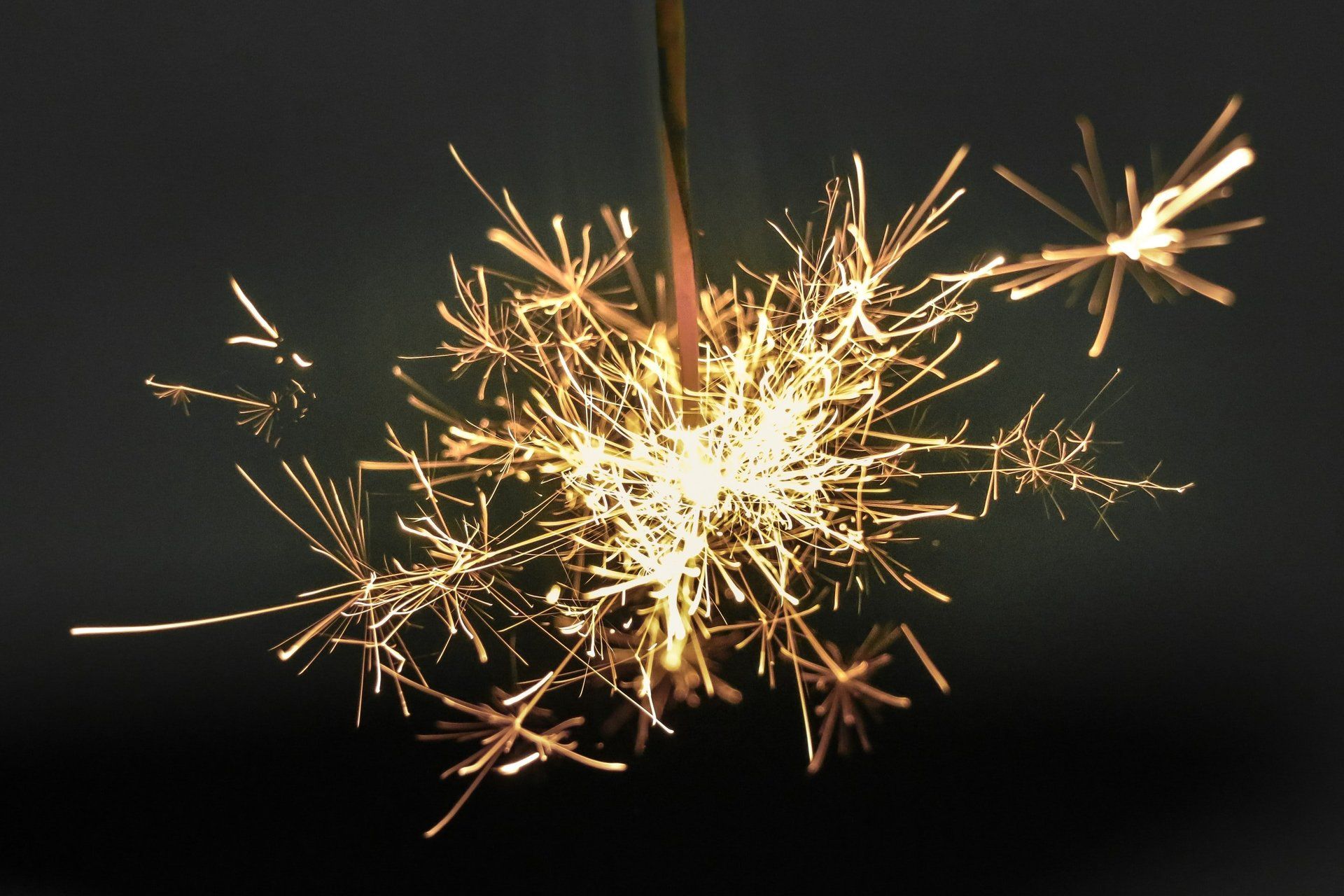 A close up of a sparkler on a black background
