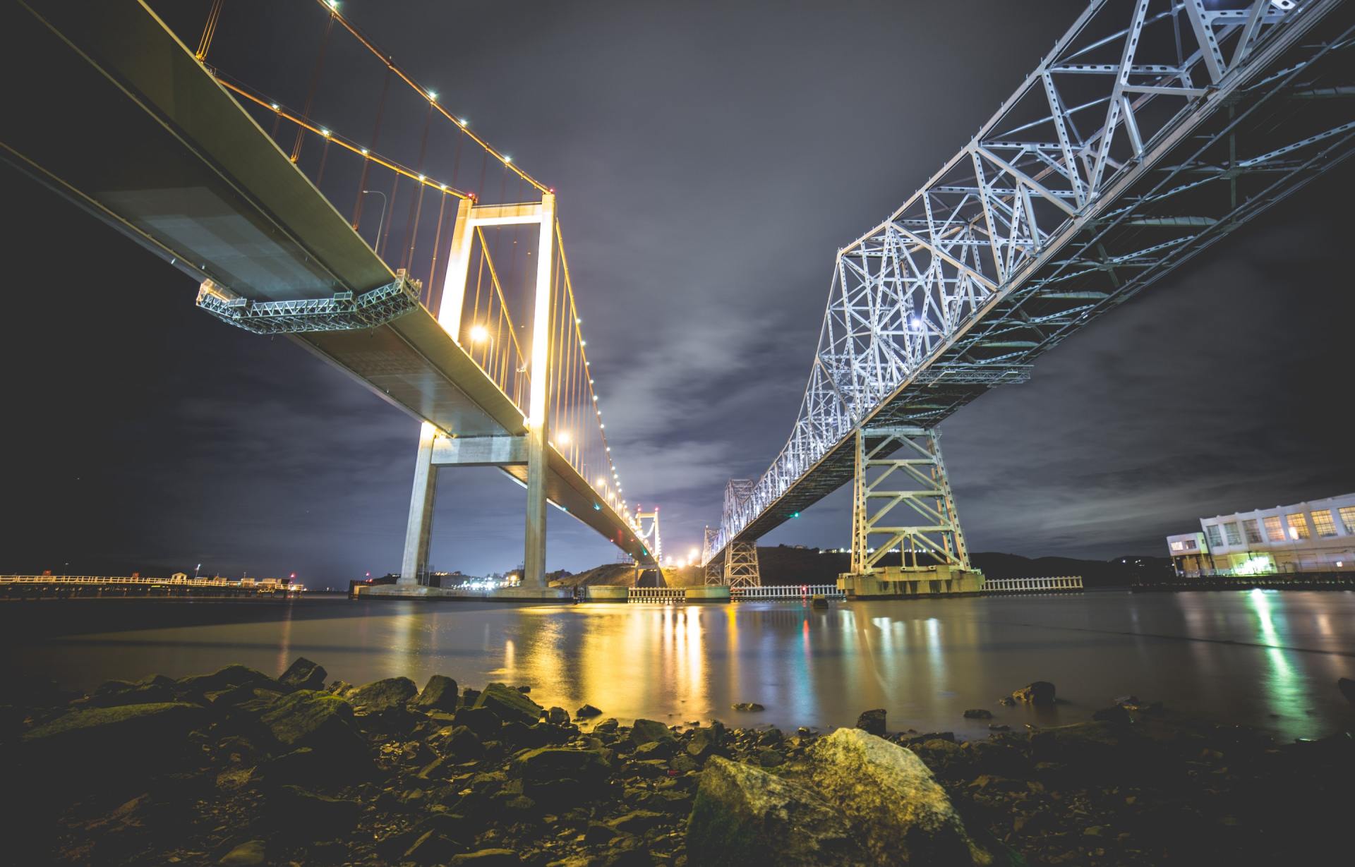 A bridge over a body of water at night.