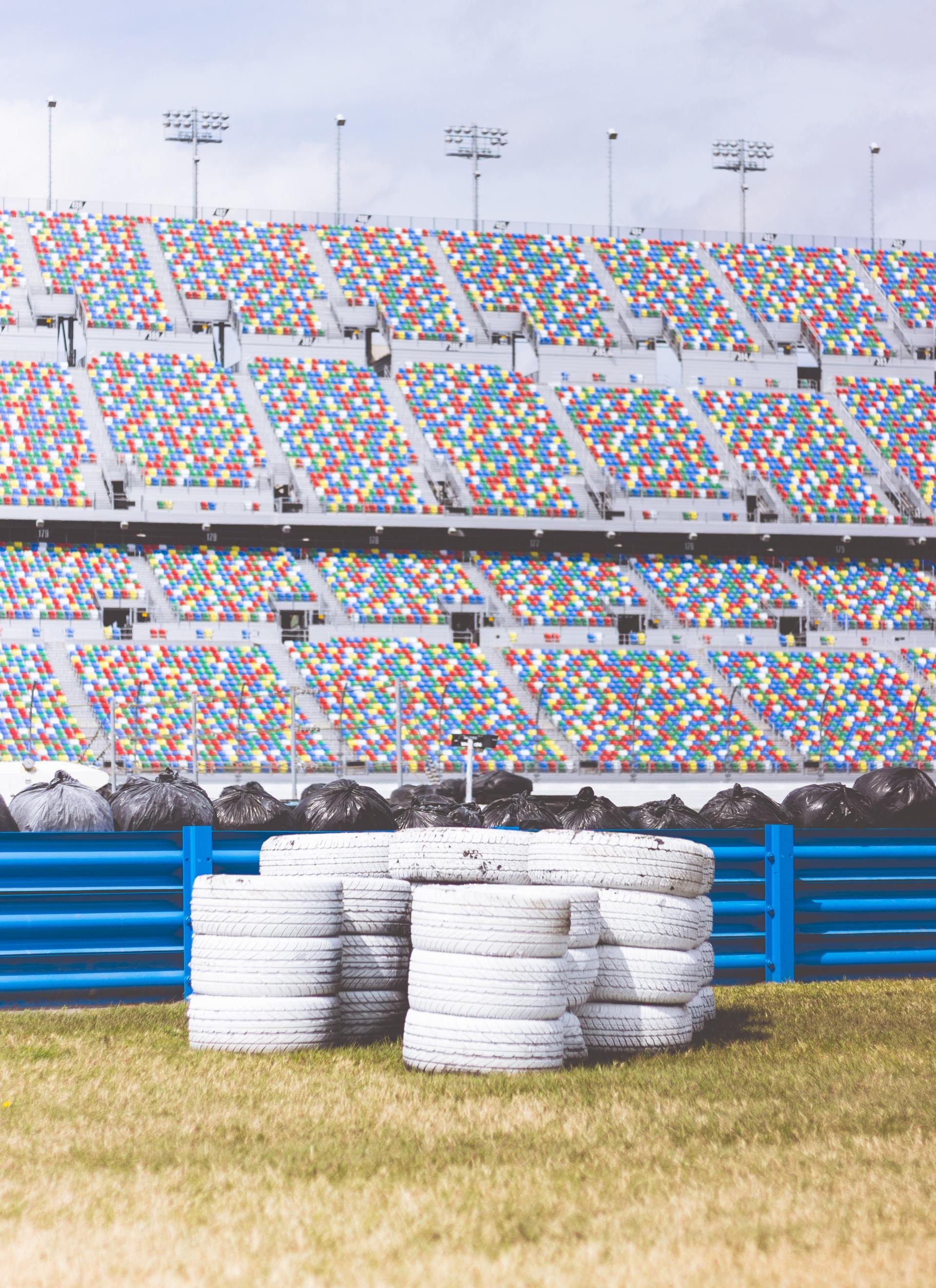 A bunch of tires are stacked on top of each other in front of a stadium.