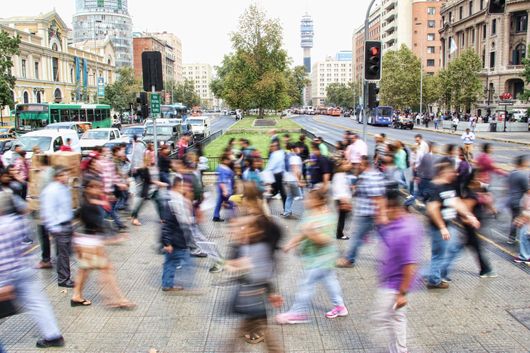 A blurry picture of a crowd of people crossing a street