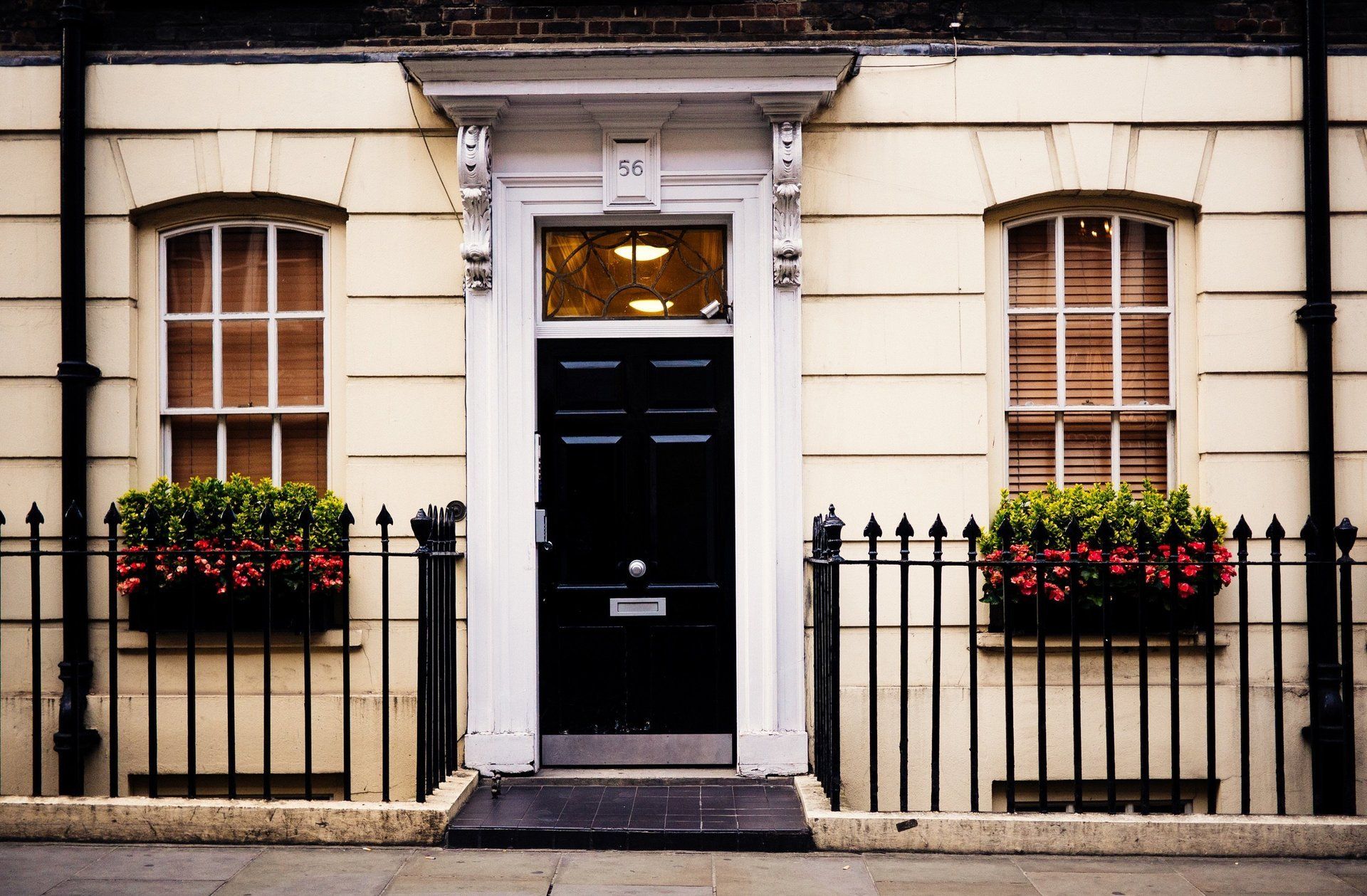 Picture of a London town house with a newly painted black front door by painters and decorators London
