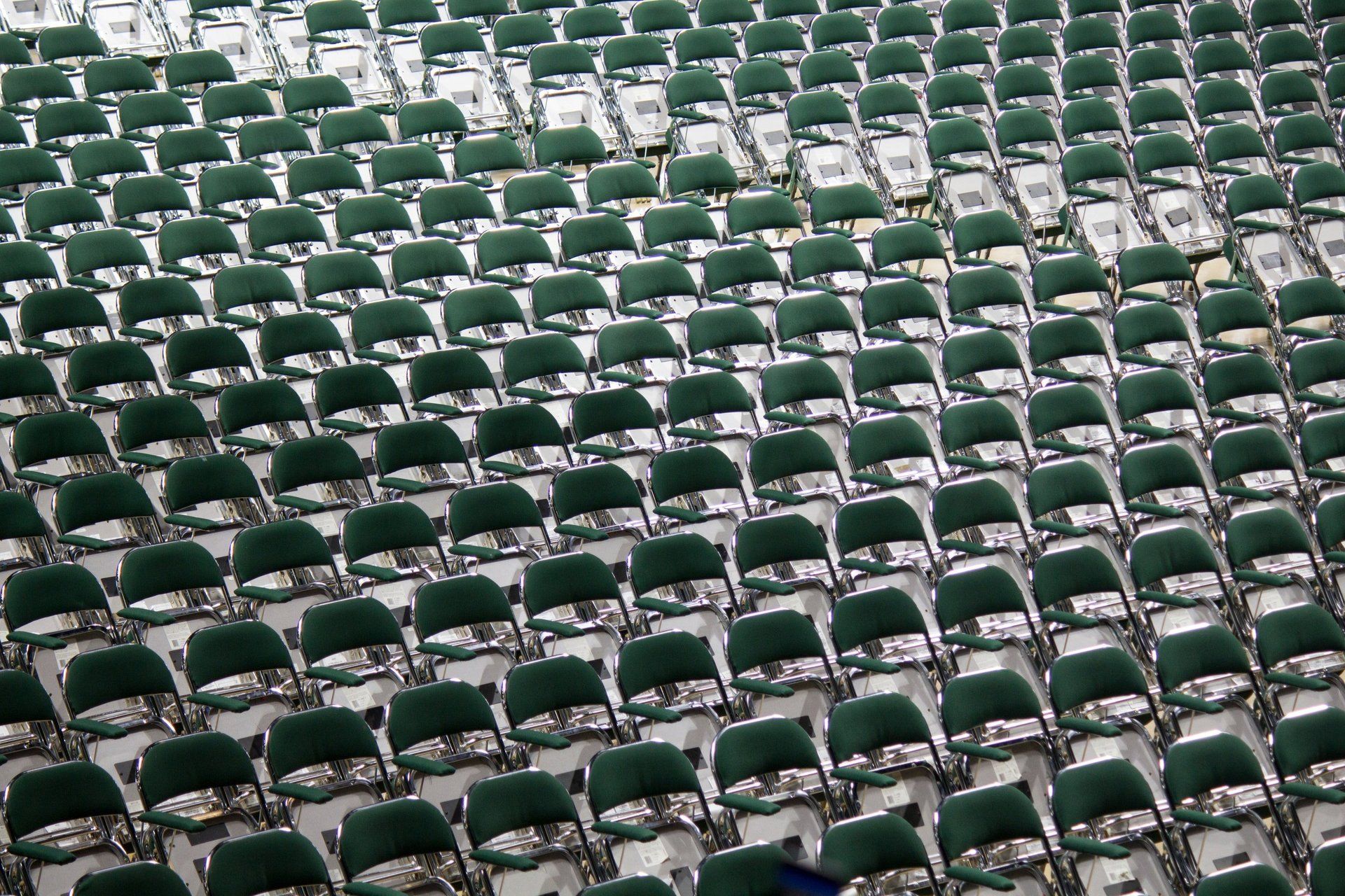 Rows of green folding chairs in a stadium