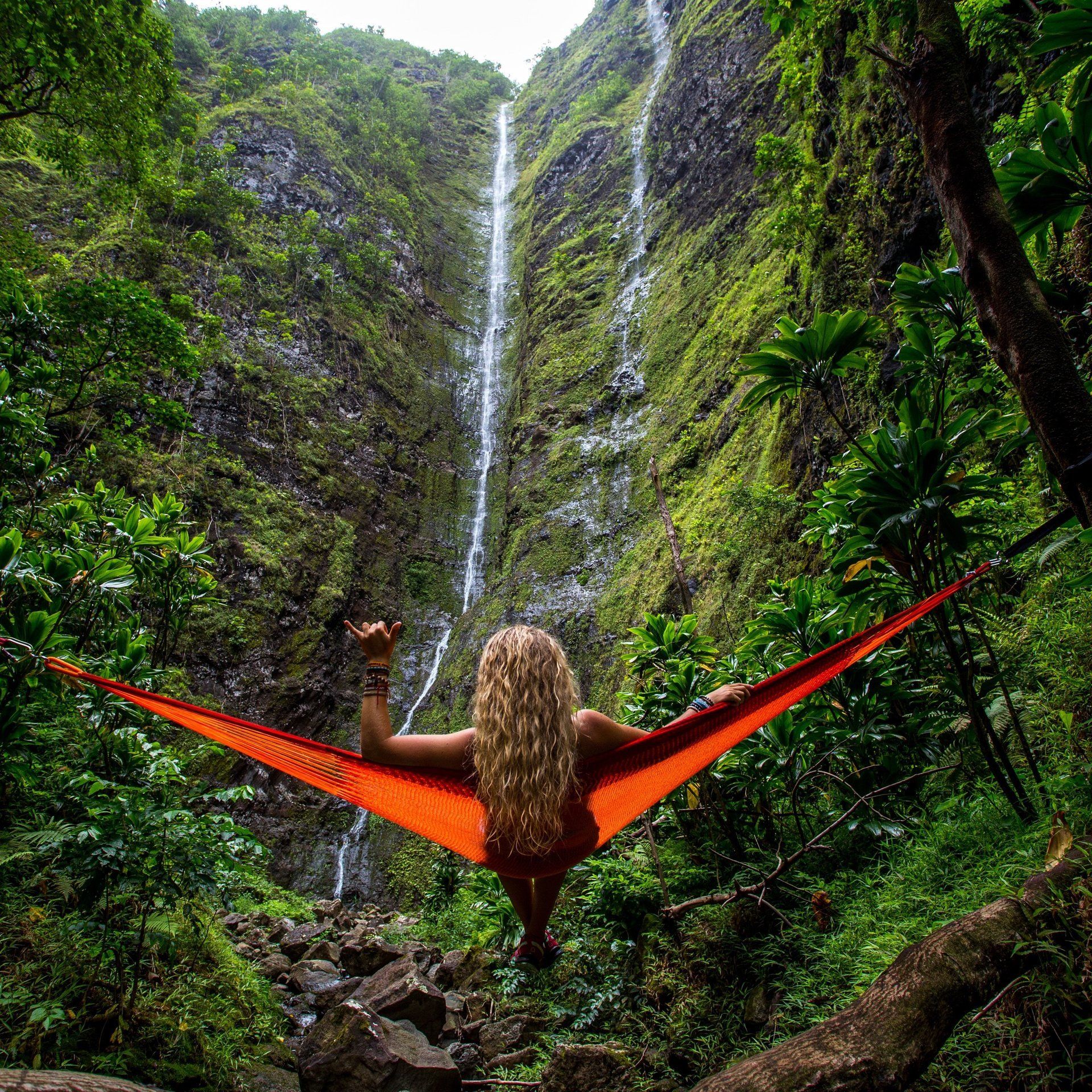 Girl relaxing in front of waterfall