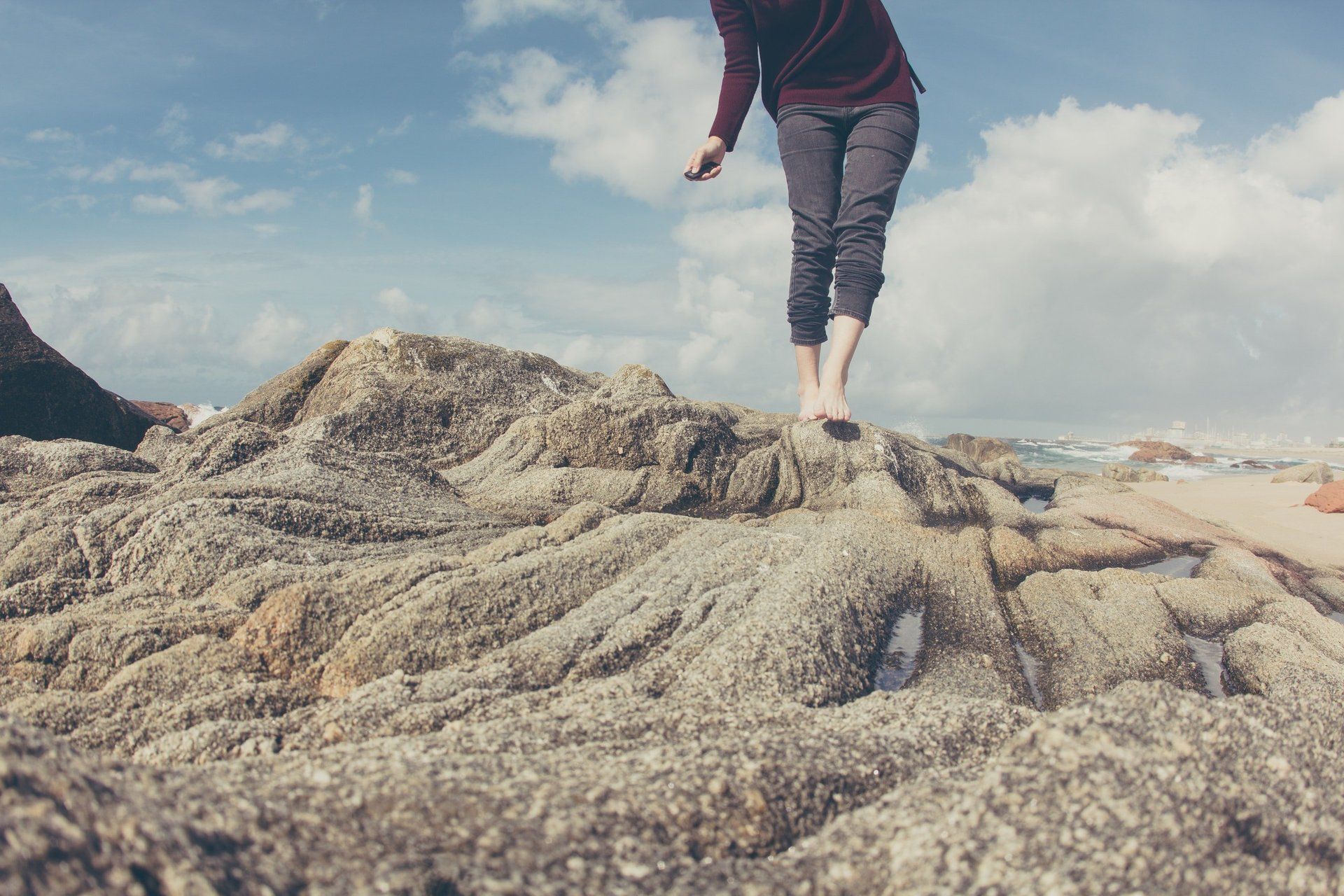 Woman walking on rocks with healthy legs after varicose vein treatment with vein specialist