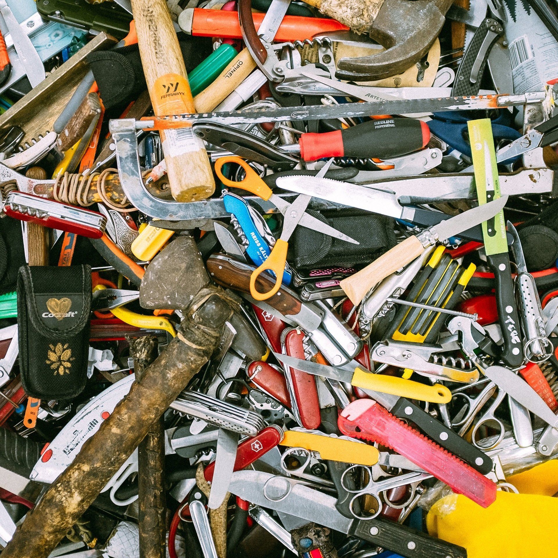 A pile of tools including a hammer and scissors