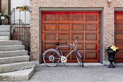 a bicycle is parked in front of a wooden garage door
