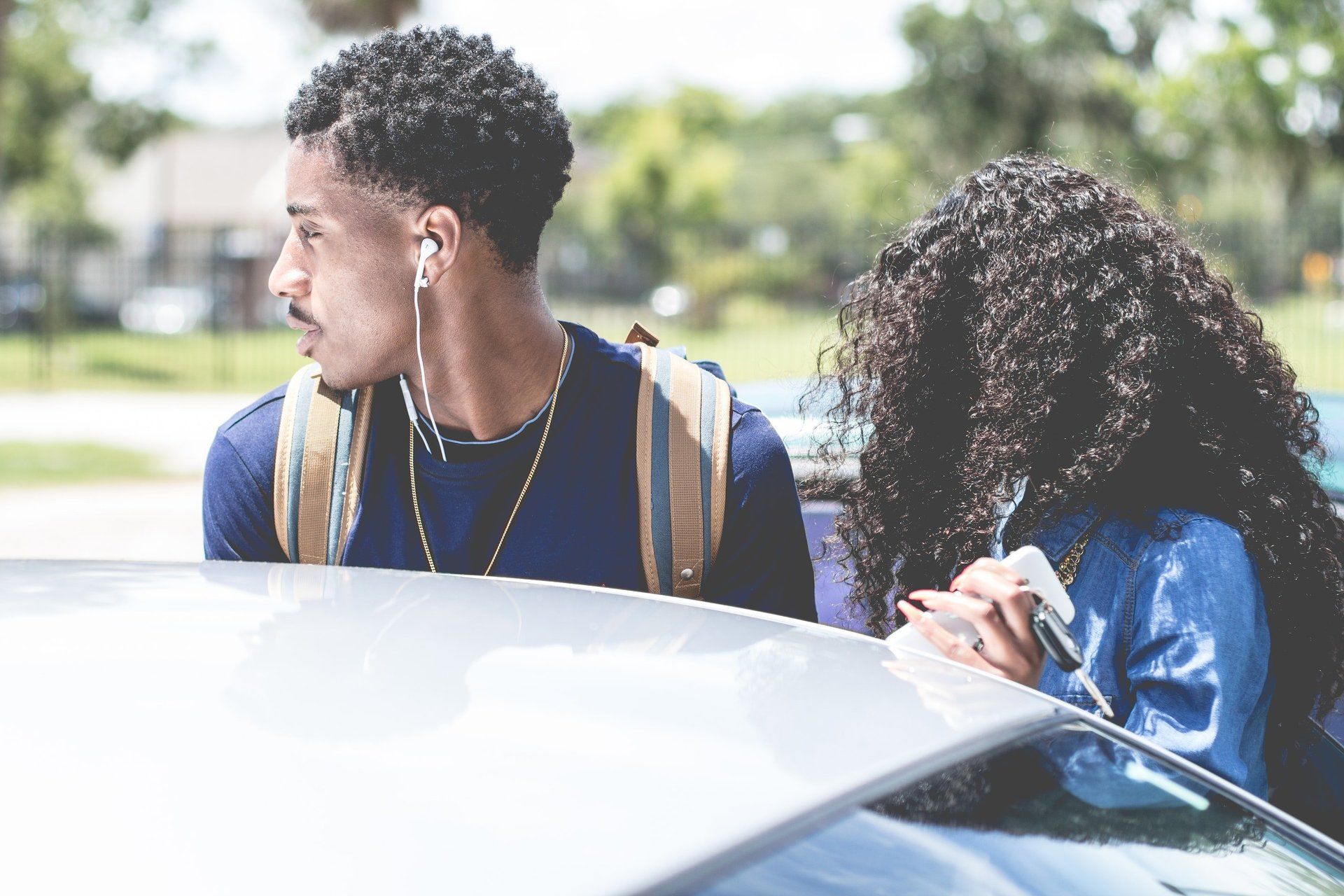A man and a woman are sitting in the back of a car.