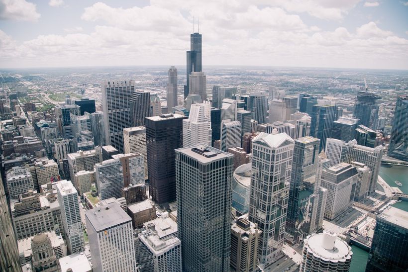 An aerial view of a city with lots of tall buildings and a river.
