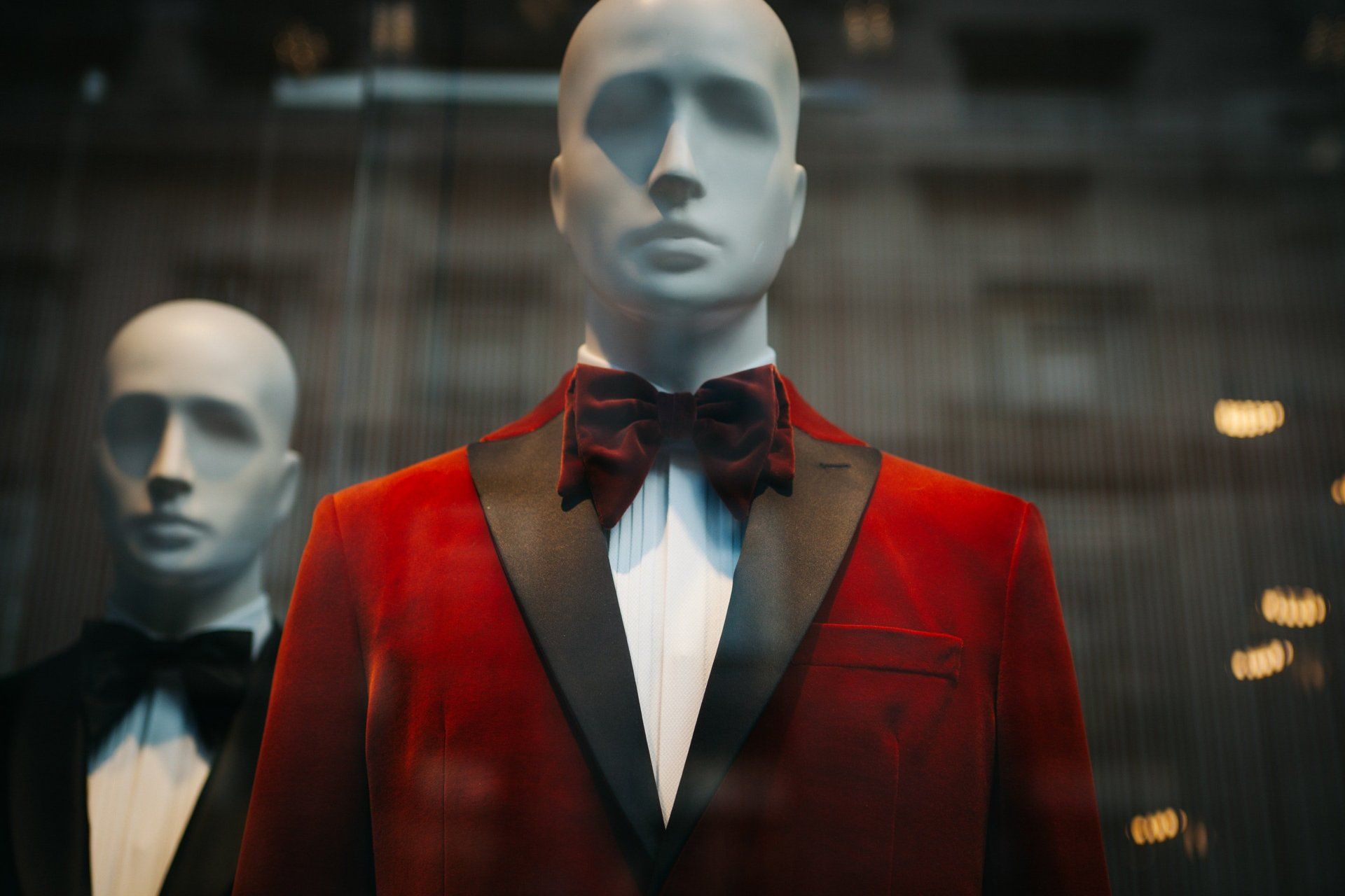 a mannequin is wearing a red tuxedo and bow tie .