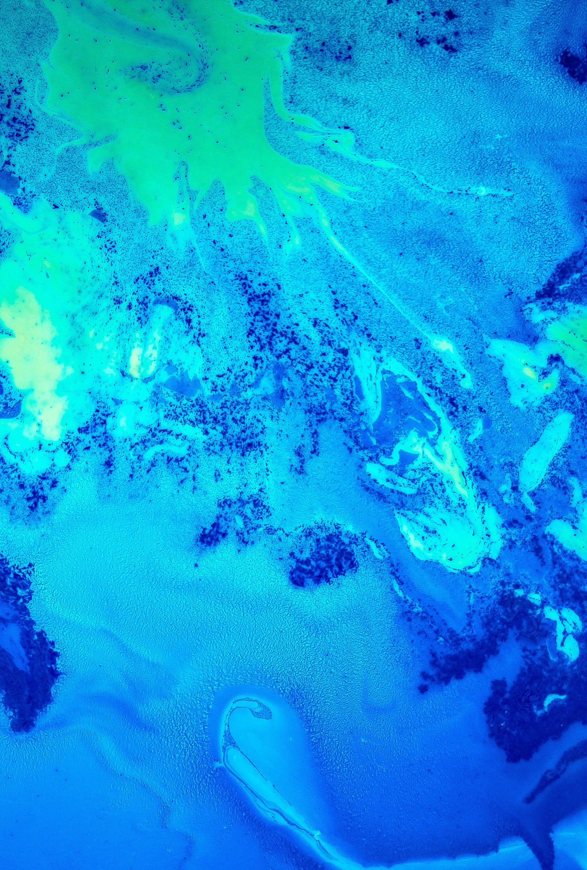 A close up of a blue and green painting on a wall.