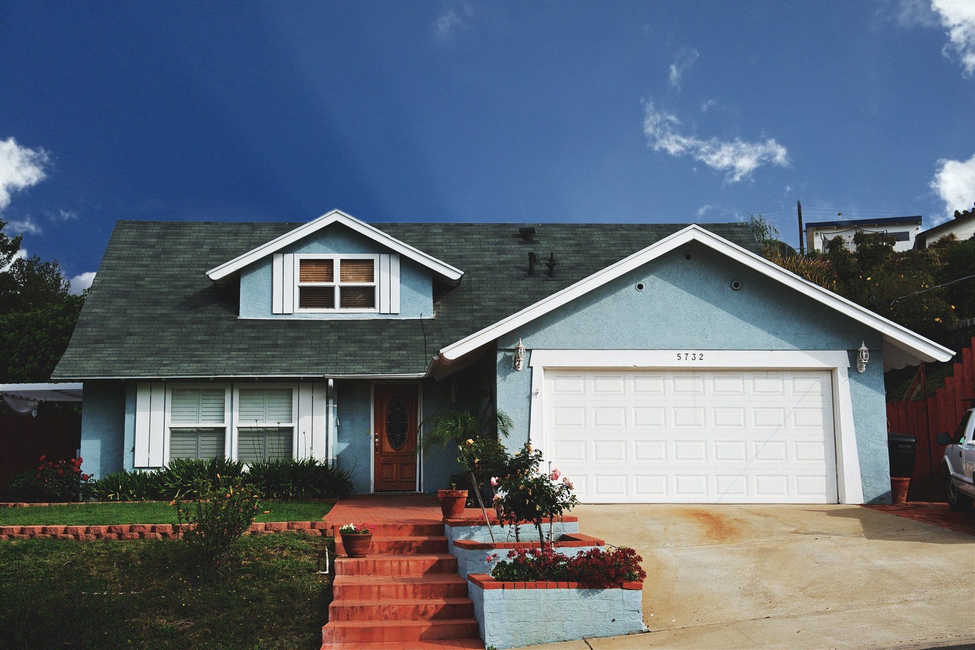 A blue house with a white garage door