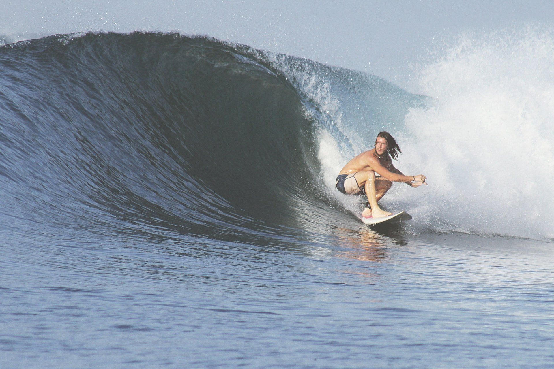 A man is riding a wave on a surfboard in the ocean.
