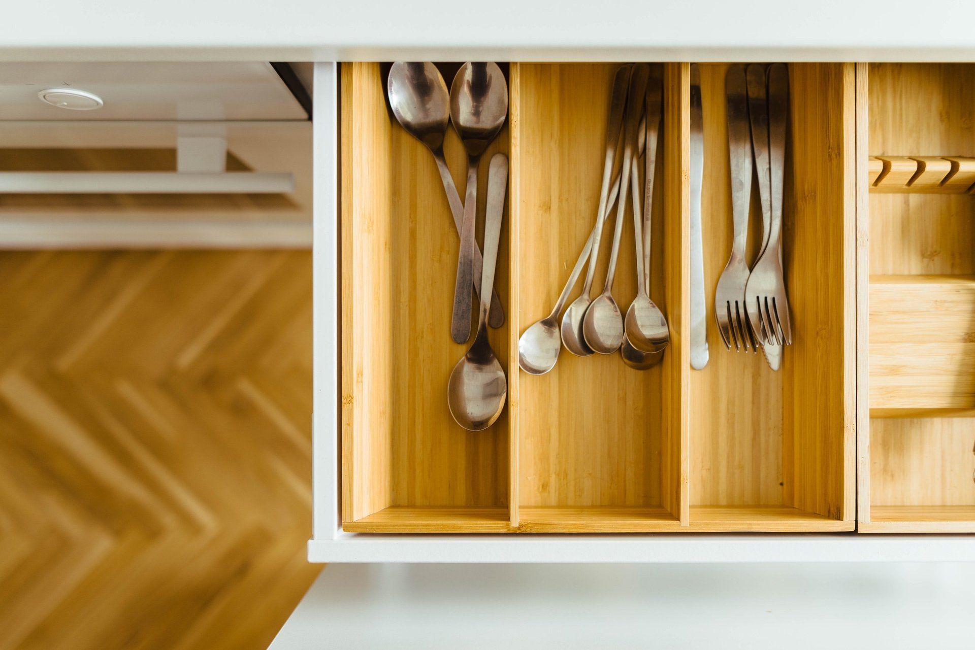 Kitchen drawer with adjustable divider to organize utensils