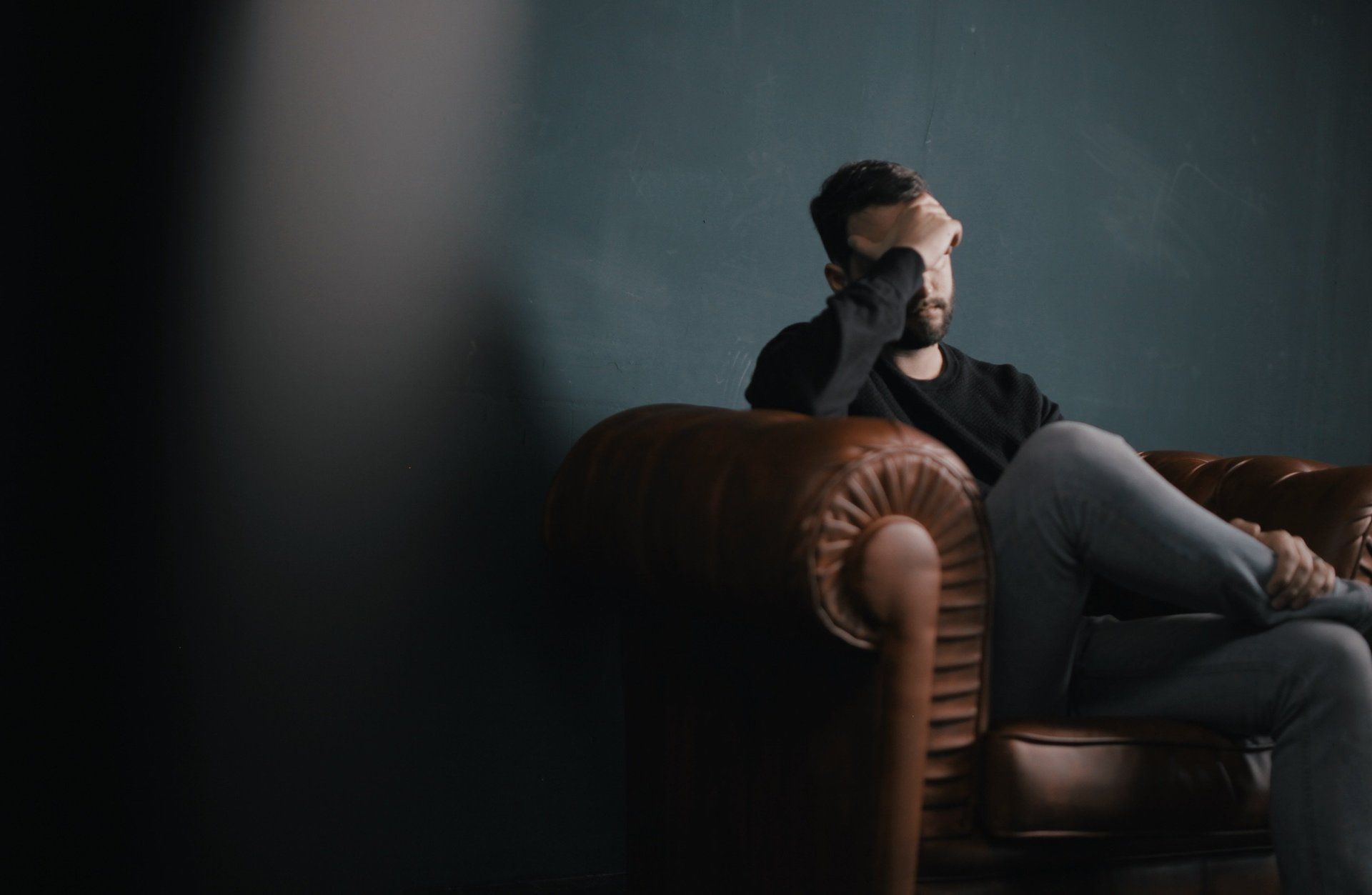 depressed man with hand on forehead