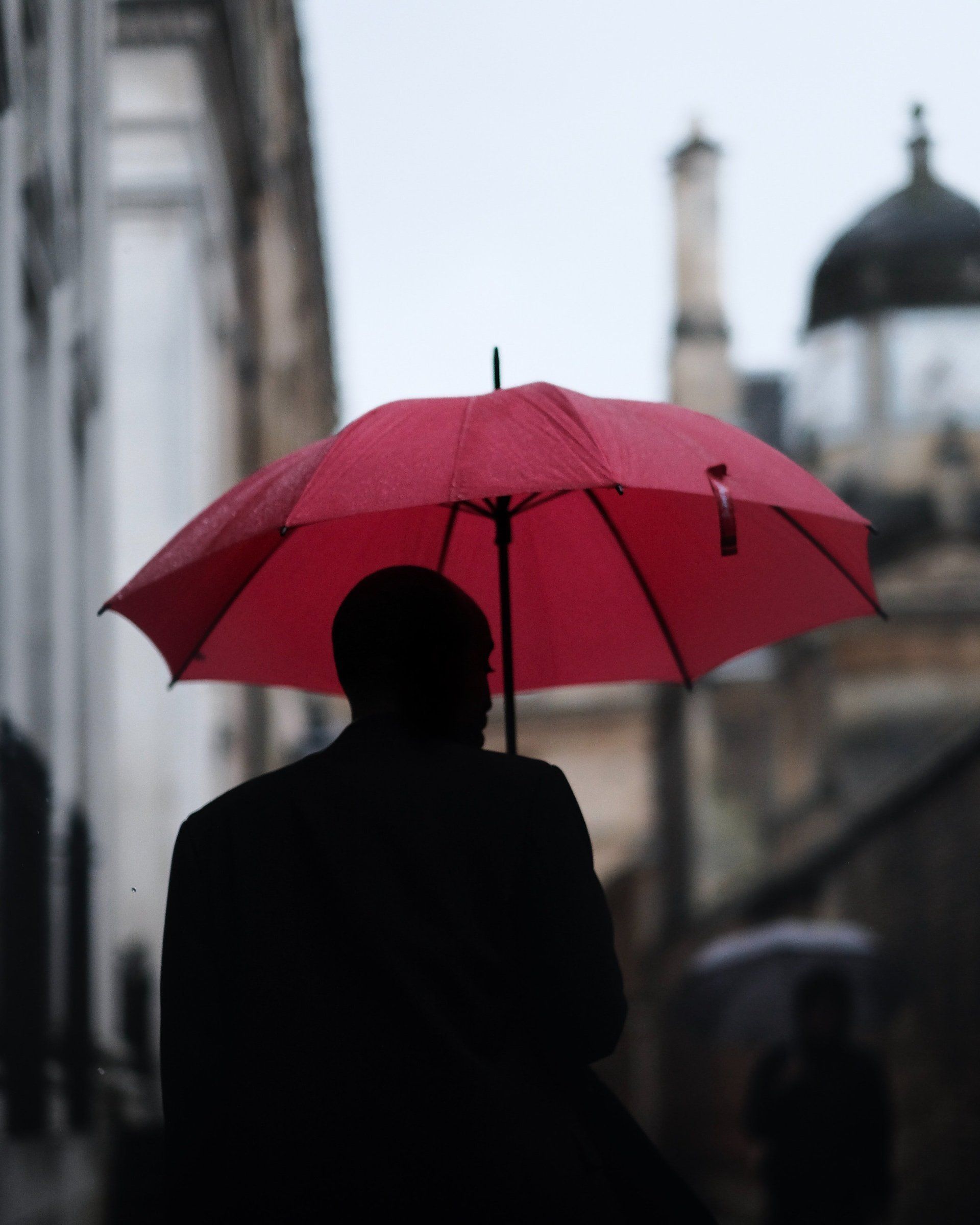 A man holding a red umbrella in the rain