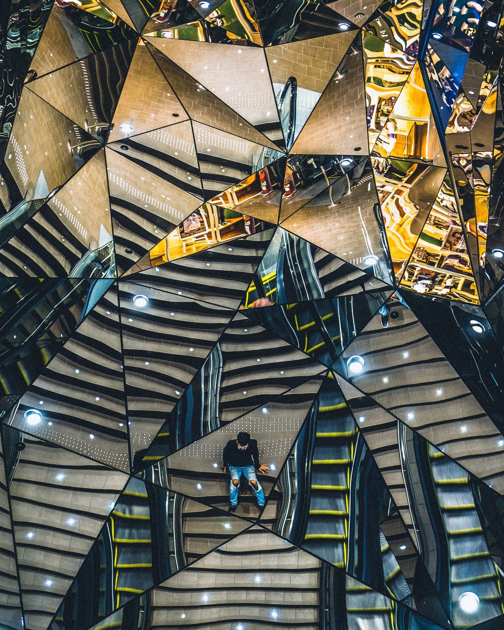 A man is standing on top of a kaleidoscope made of mirrors.