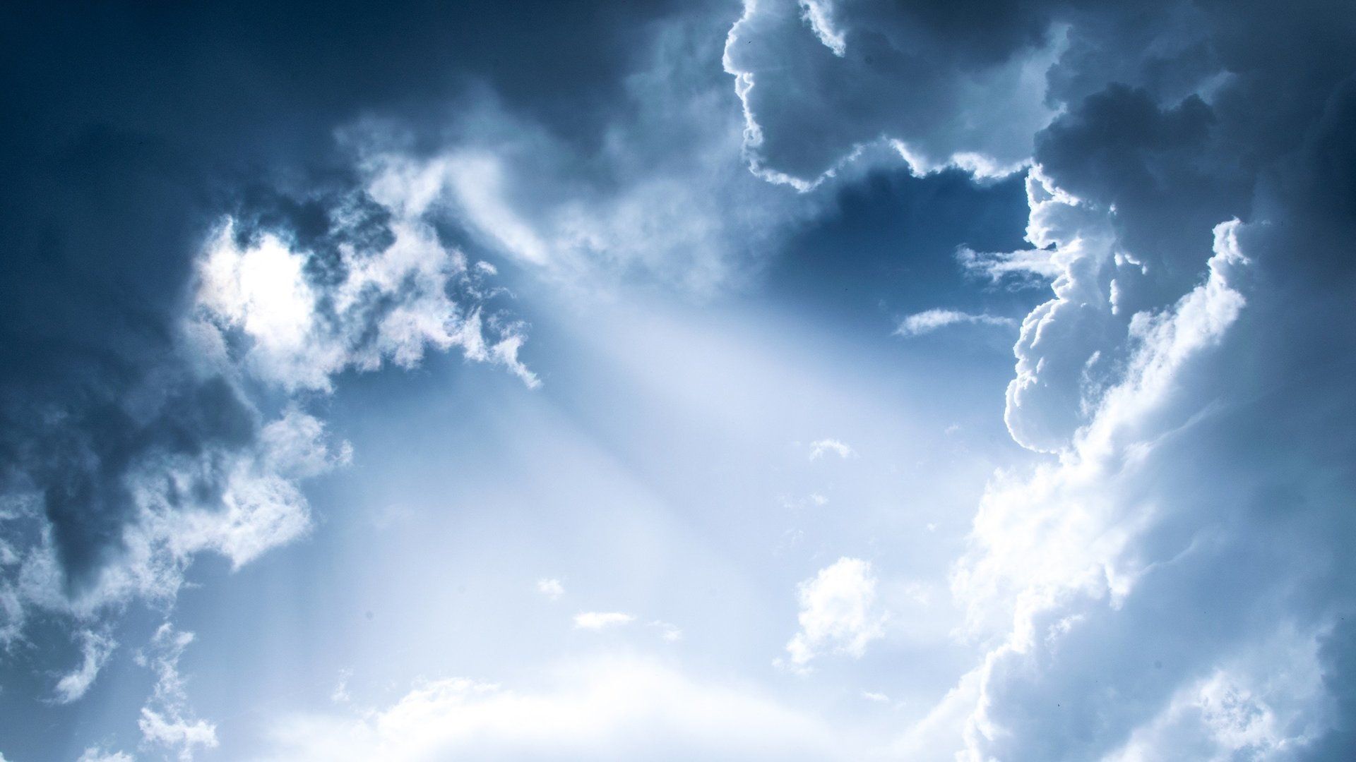 A picture of the sky and clouds with sun shining through.