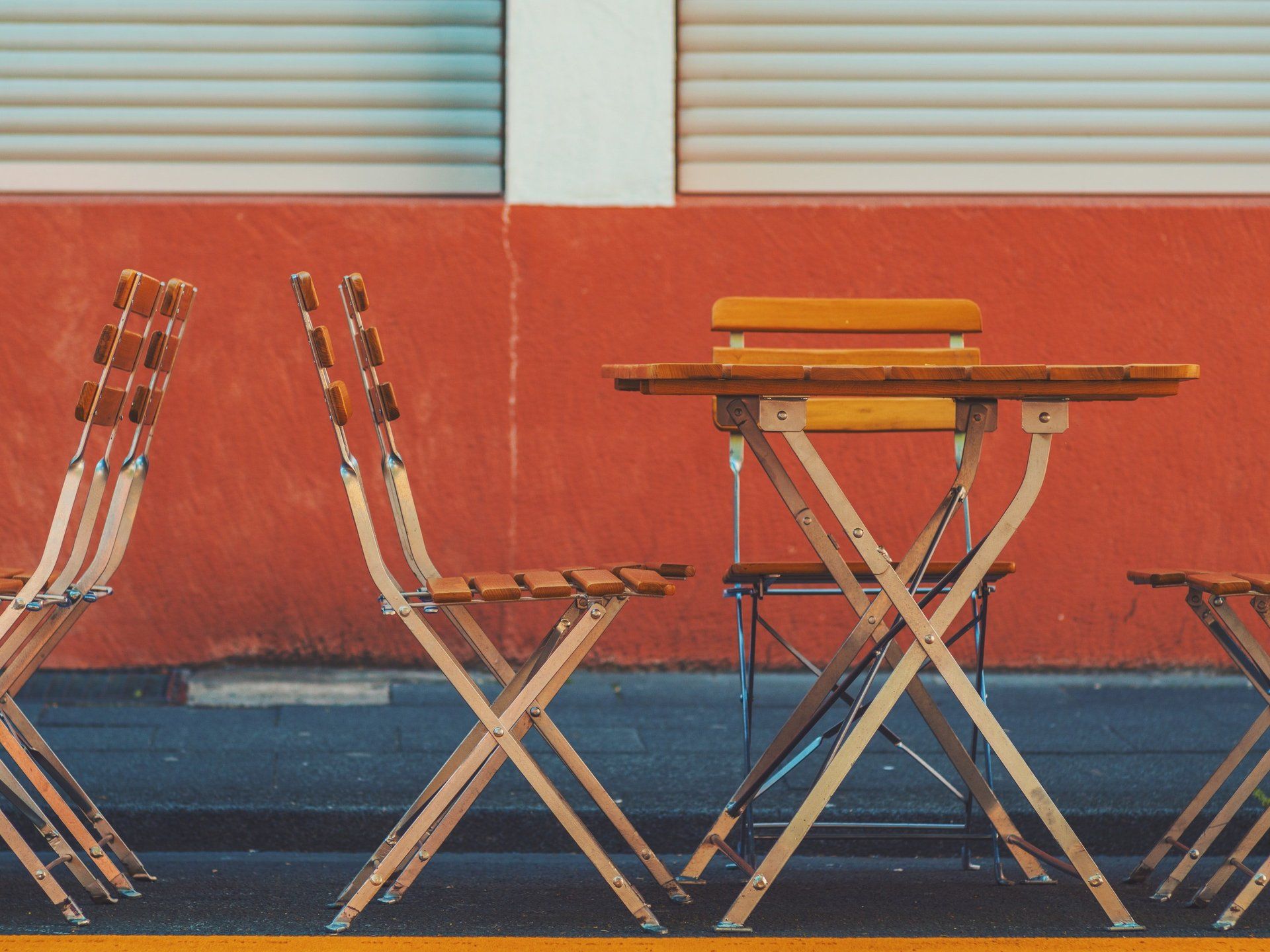 A table and chairs in front of a red wall