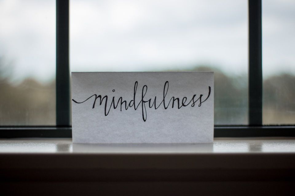 une étiquette posée devant une fenêtre et qui indique le mot mindfulness