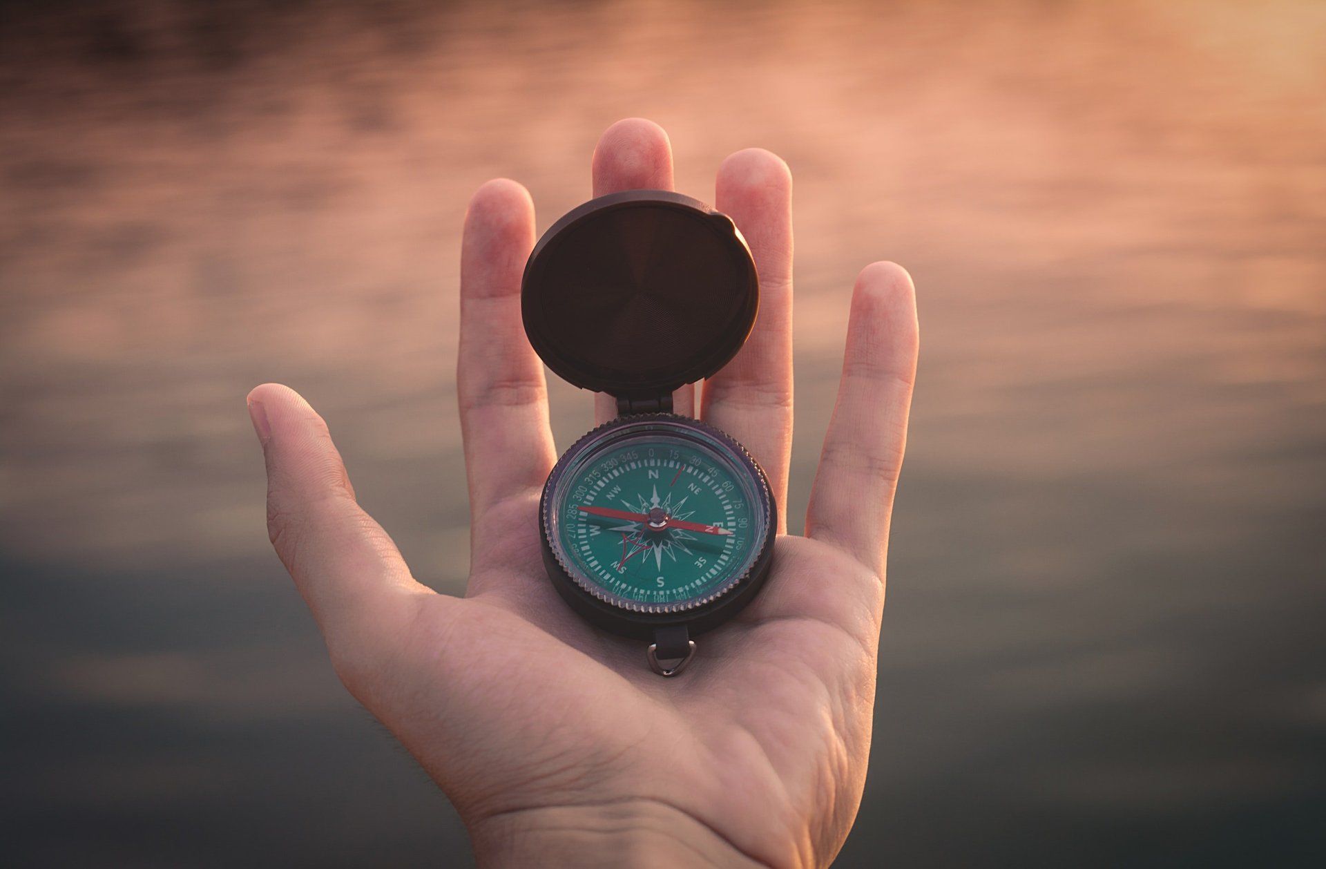 A hand holding a compass (God’s Word is Our Guide - Daily Devotional)