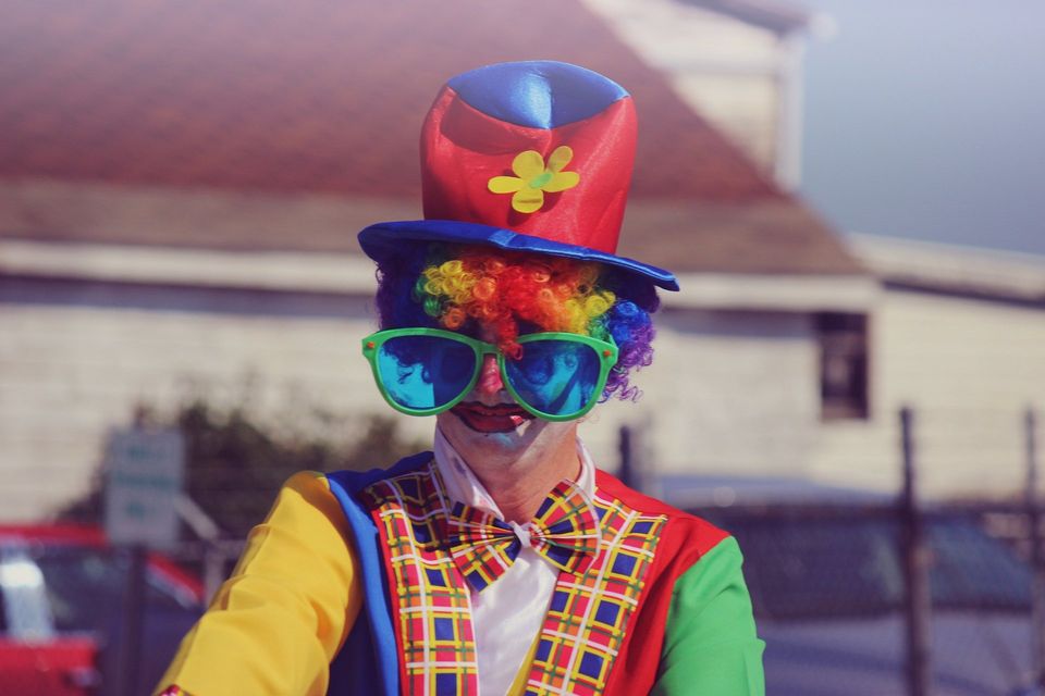 Clown dressed up makes people smile as does joking and life.