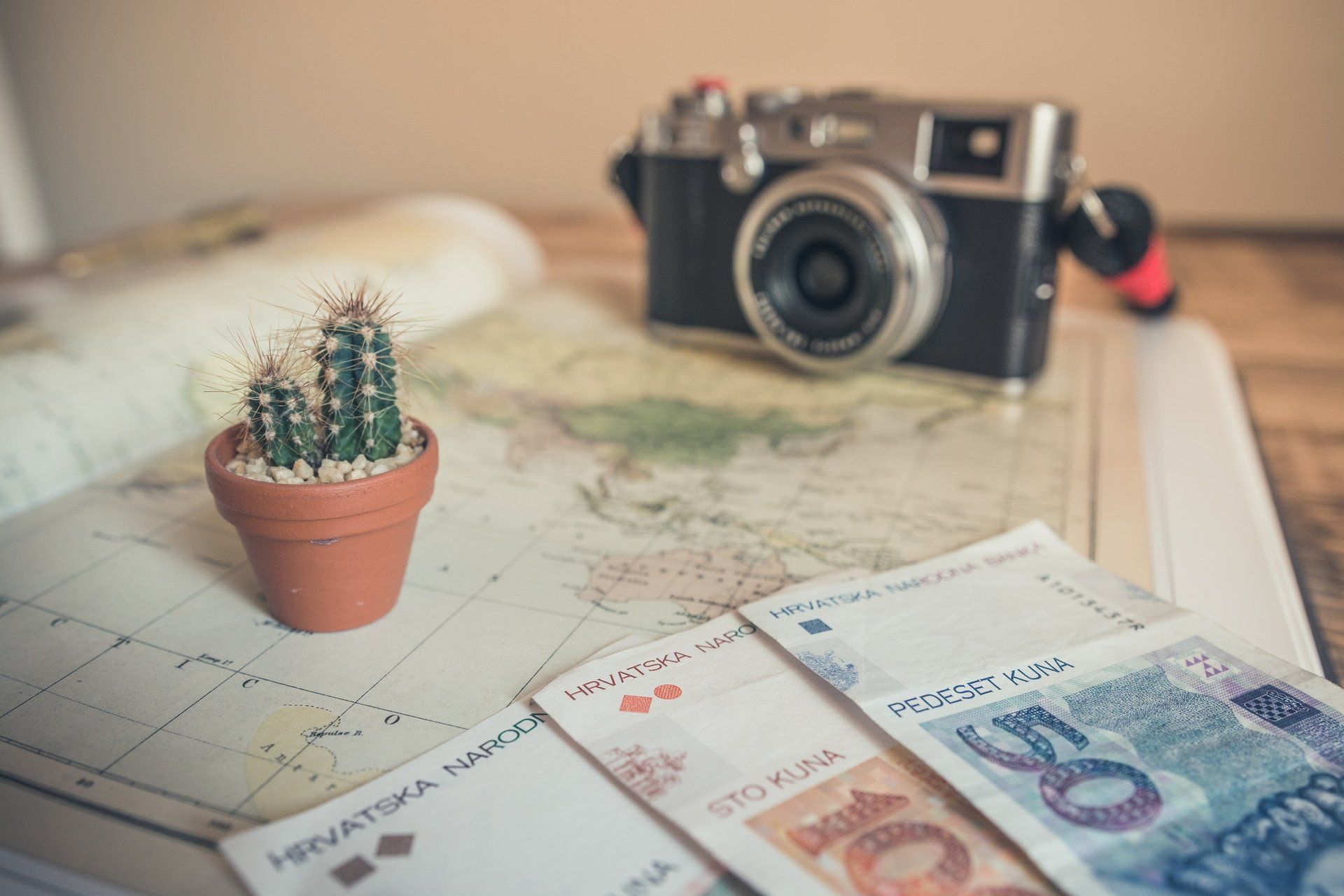 Foreign currency, travel map and camera on a table