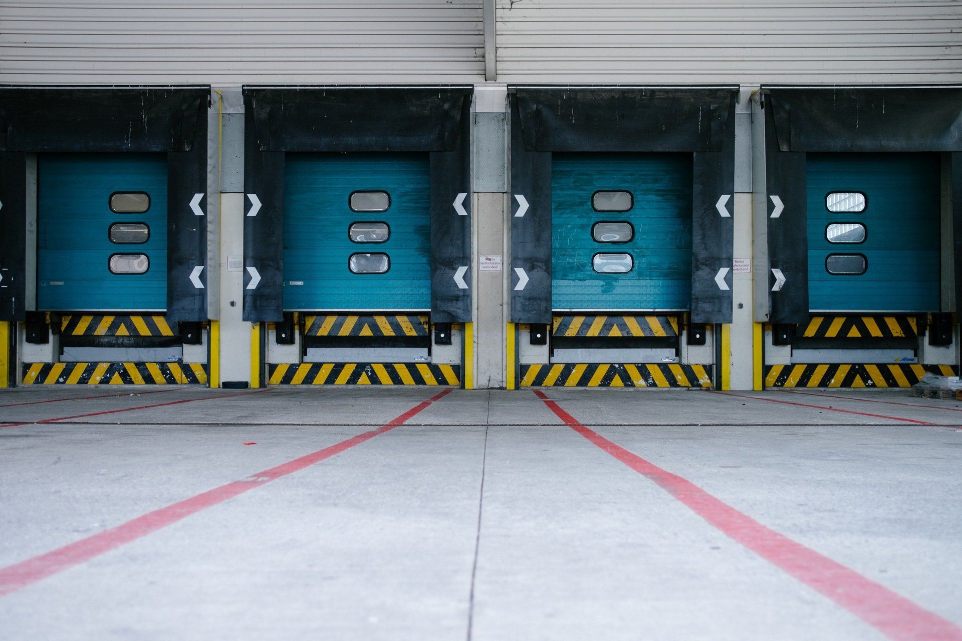 A row of blue loading doors in a warehouse.