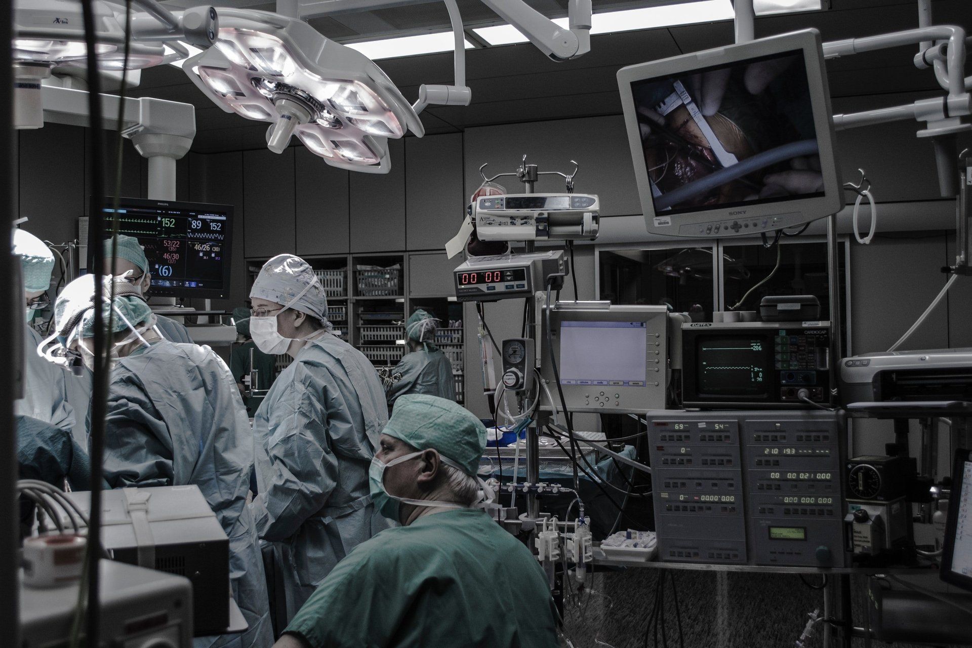 A group of surgeons are operating on a patient in an operating room.