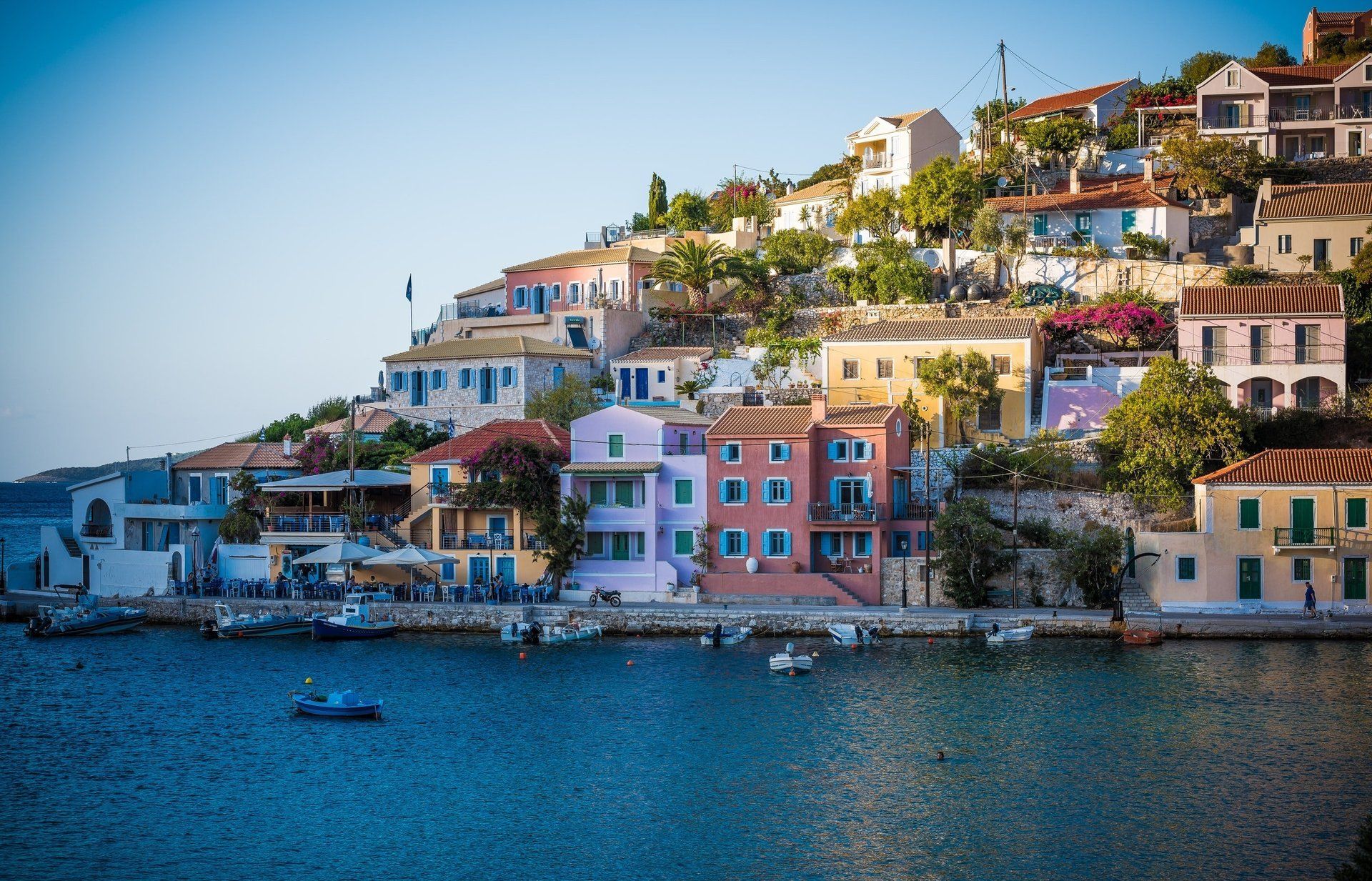 A row of houses on a hill overlooking a body of water