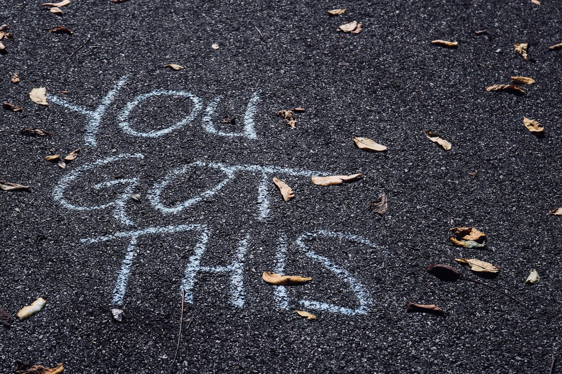 the words `` you got this '' are written in chalk on the ground .
