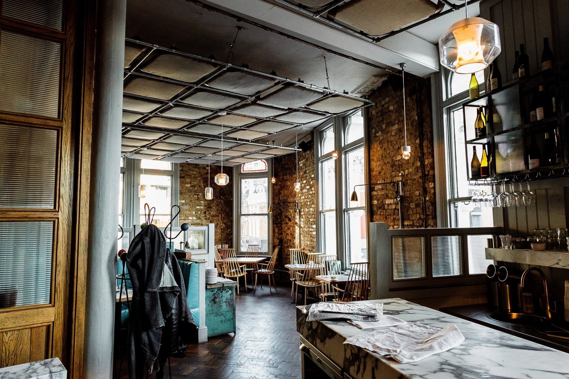 A restaurant with a lot of windows and tables and chairs.