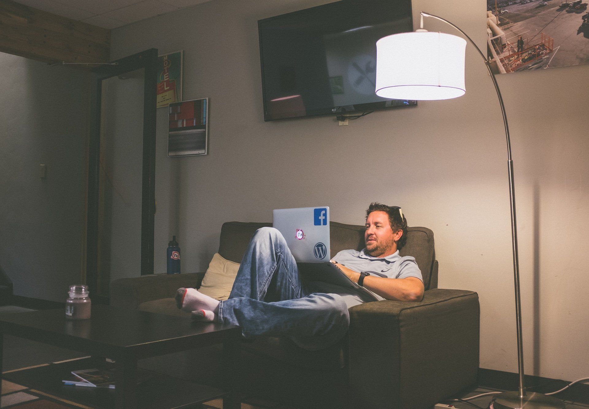 Man working on computer while lounging on couch