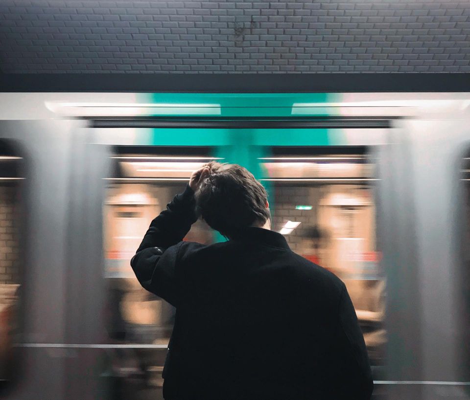 A man pulling his hair standing in front of a moving train