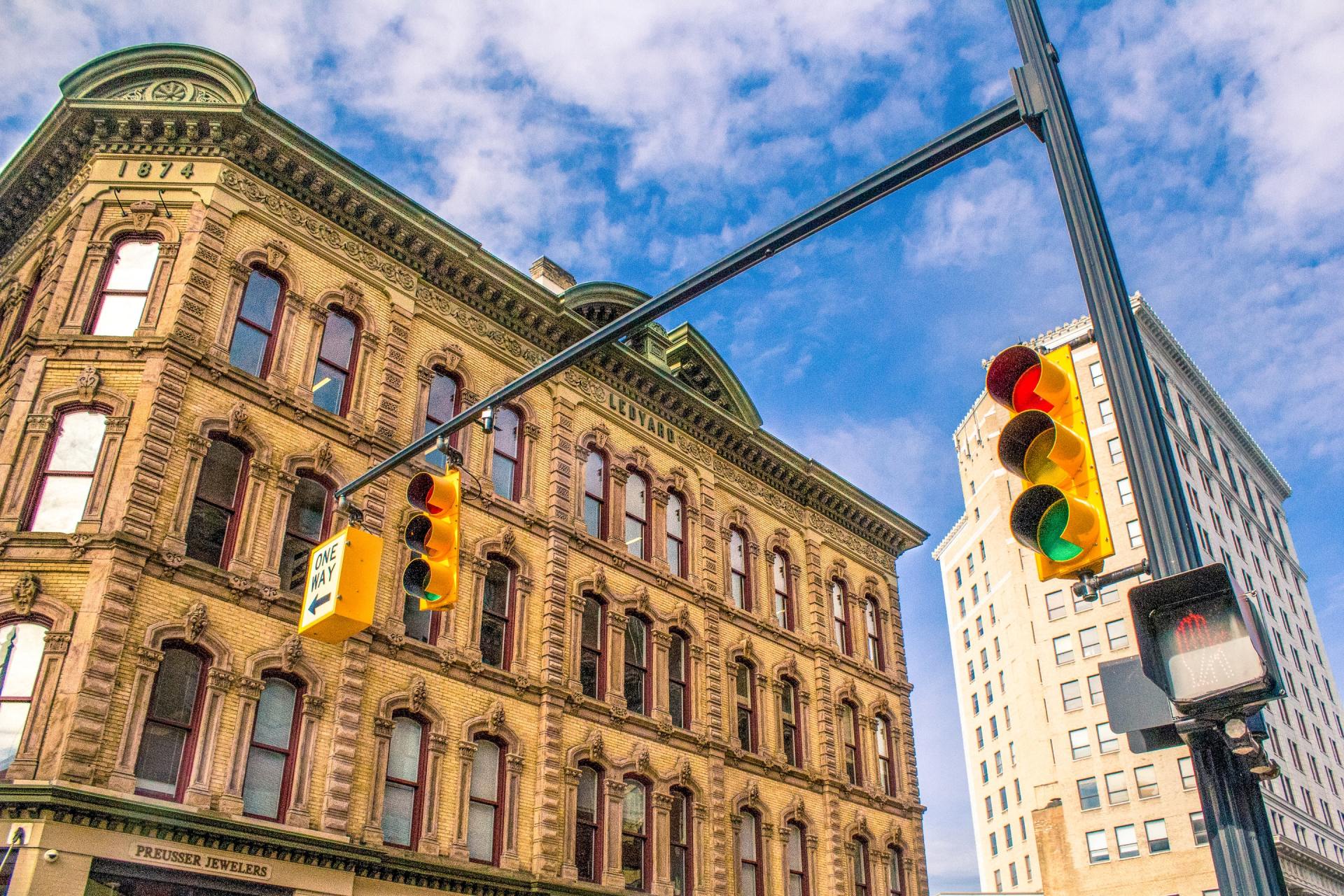 A traffic light is hanging from a pole in front of a building.