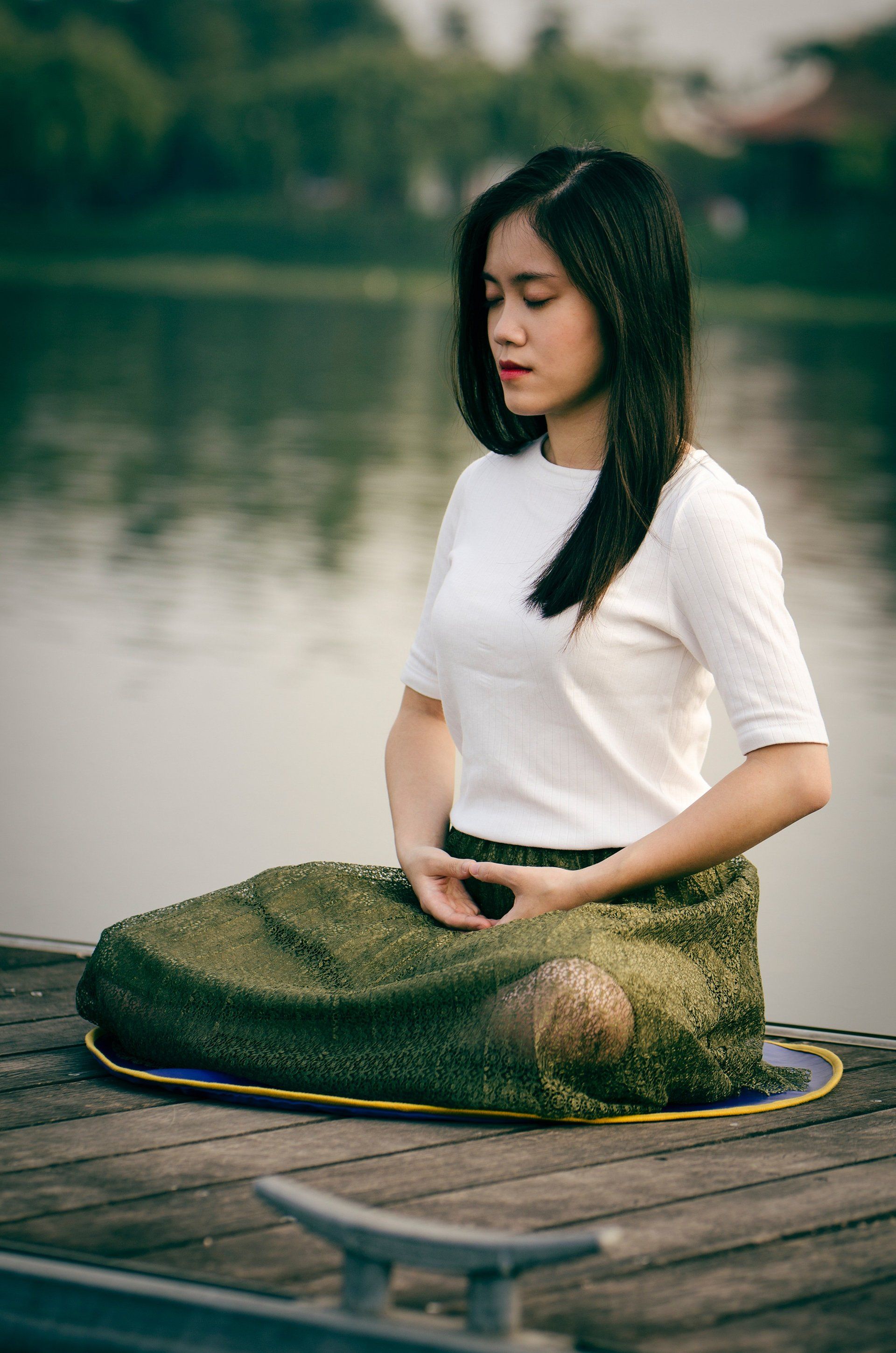 Woman meditating near a lake