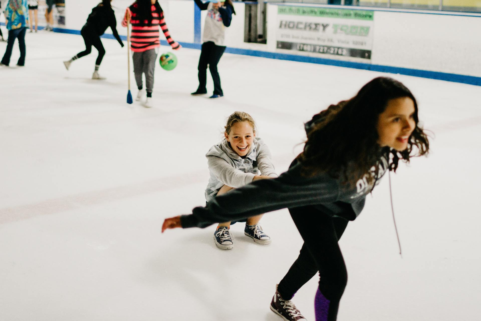 Een groep kinderen schaatst op een ijsbaan.