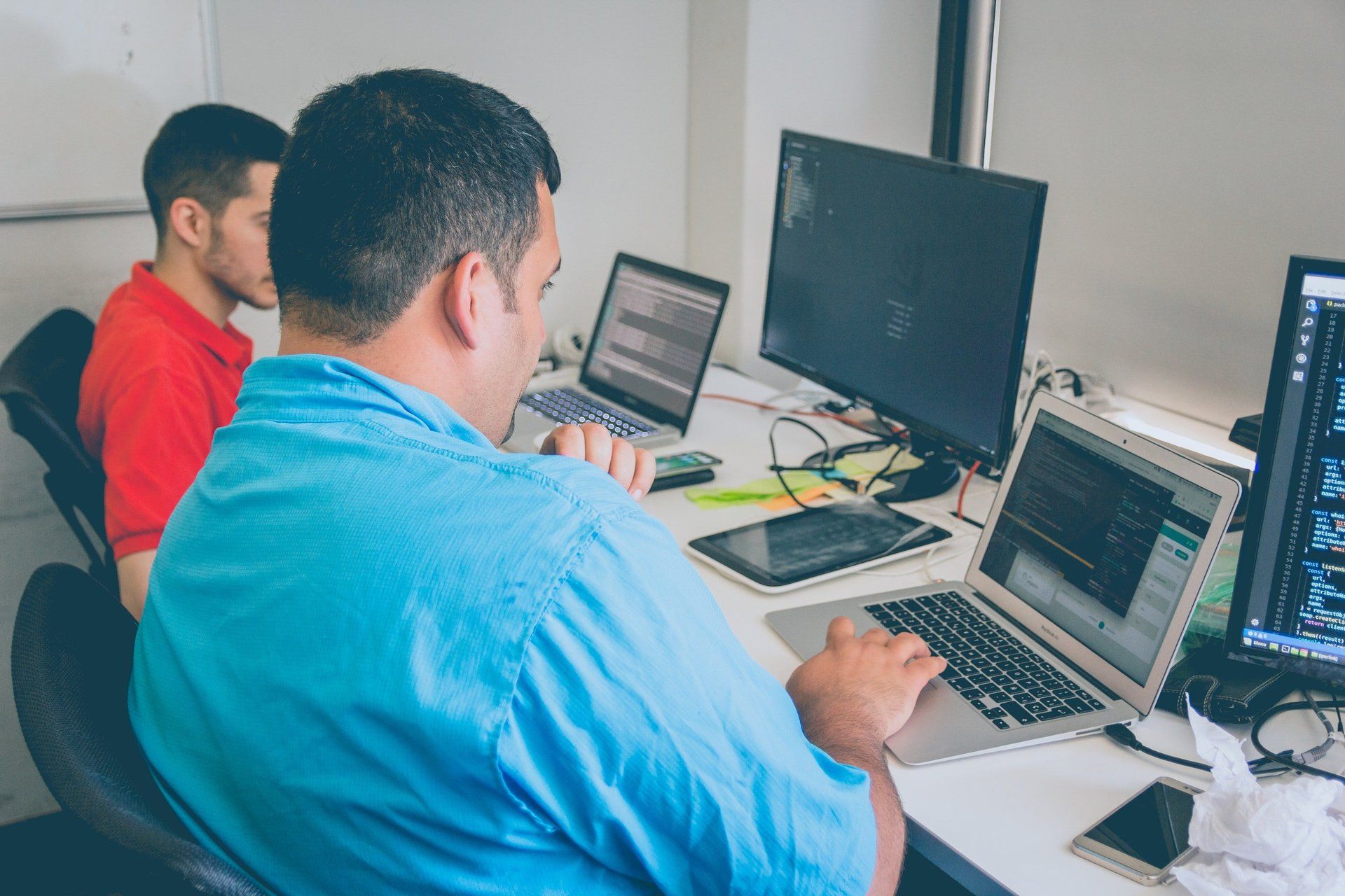 A man is sitting at a desk using a laptop computer.