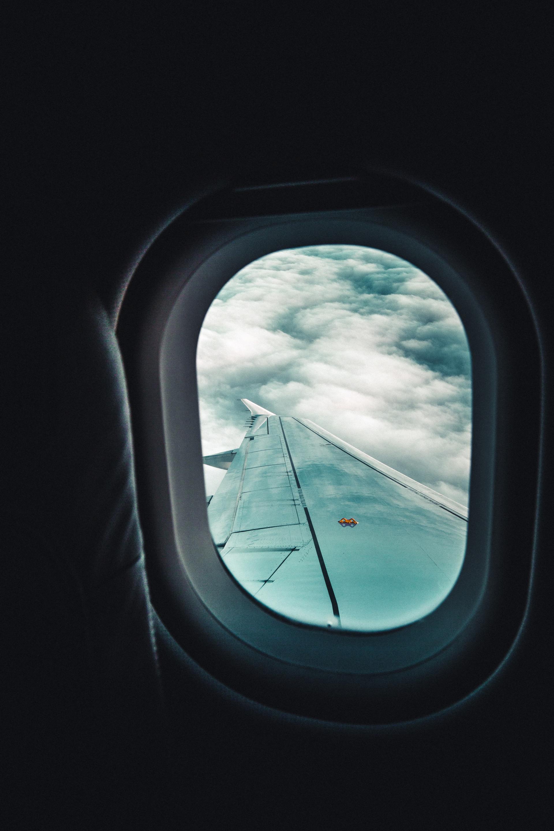 The view out the window of a plane and looking at a plane wing