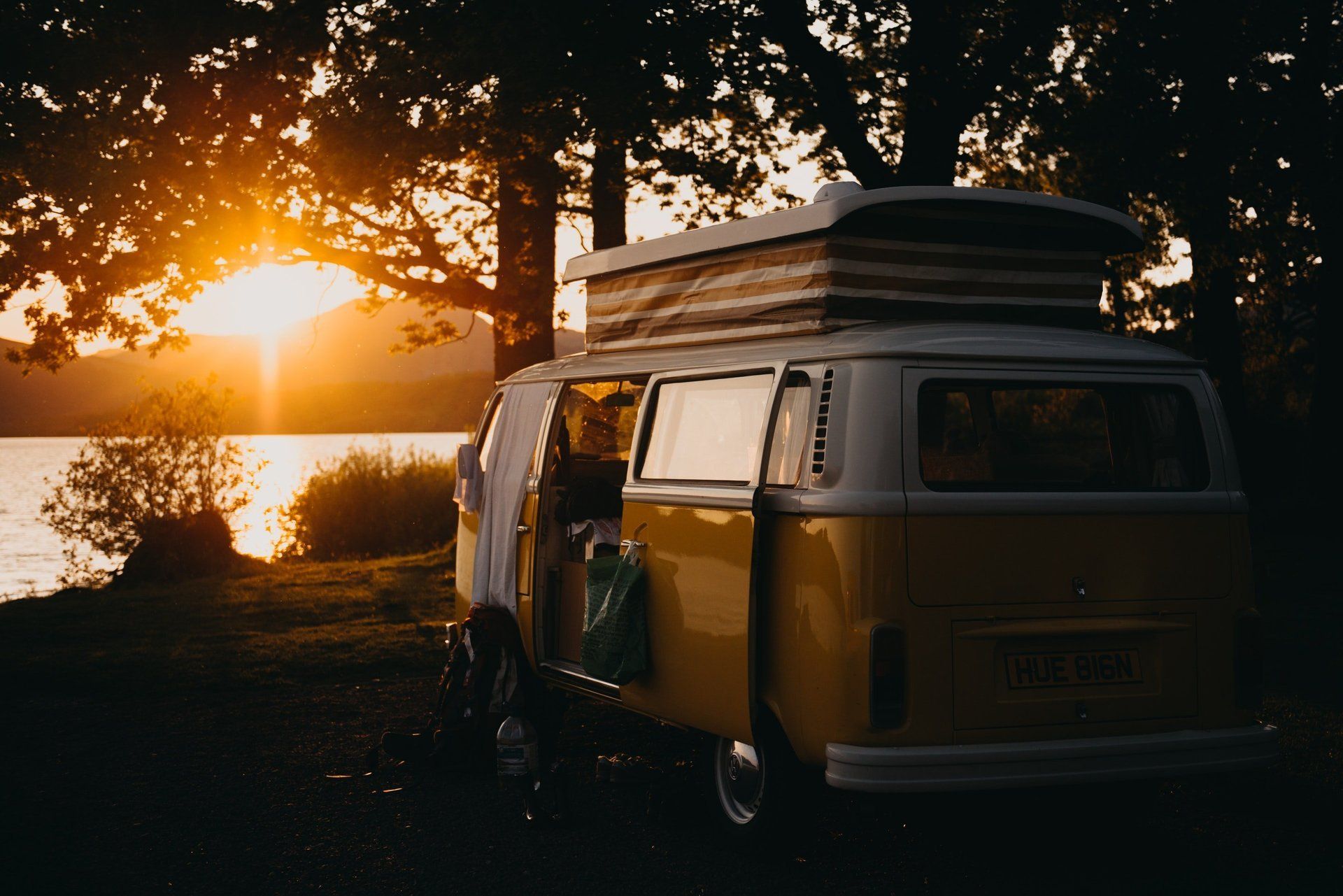 Camper parked by lake at sunset